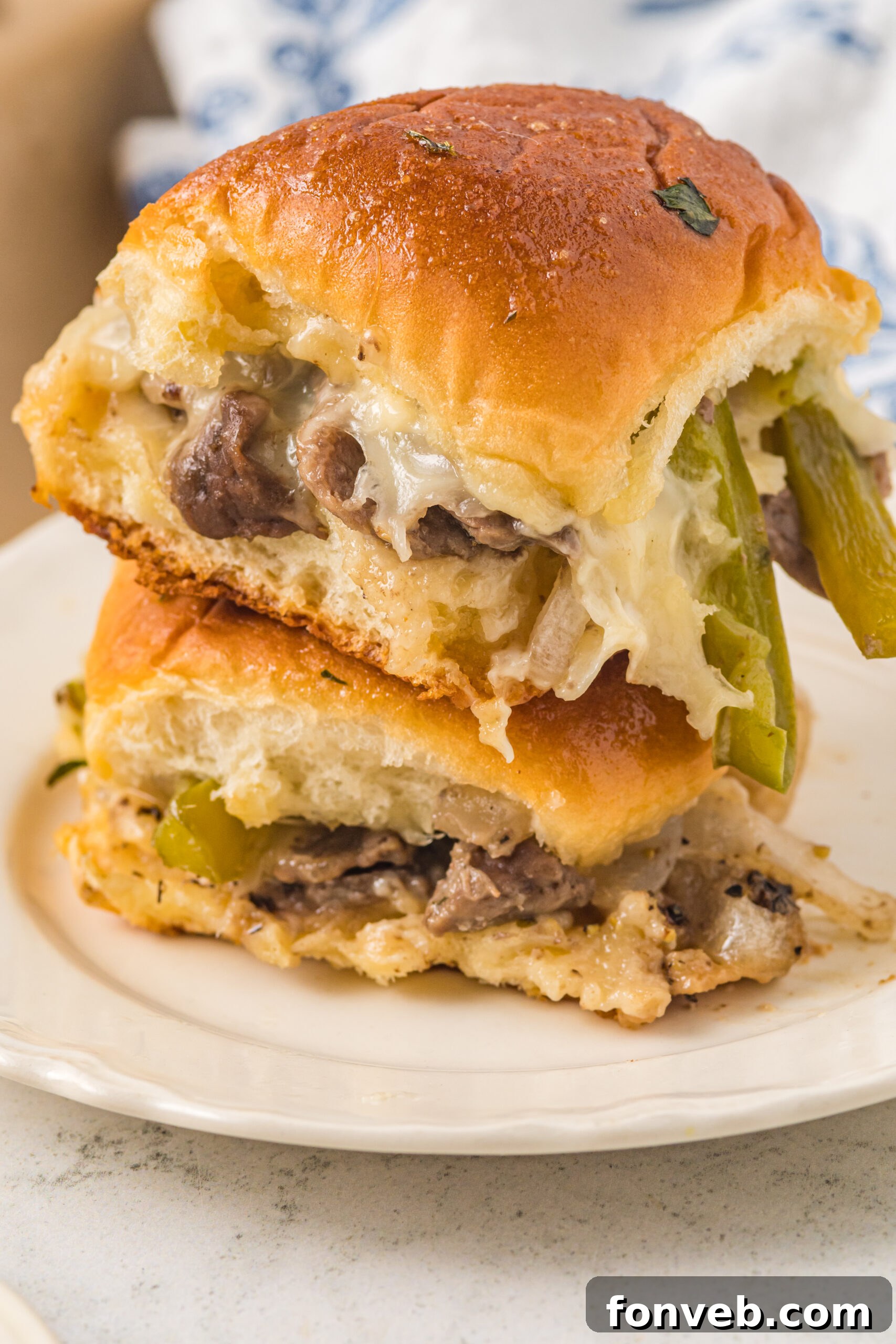 Ultimate Philly Cheesesteak Sliders 12 Two sliders stacked on a white plate.