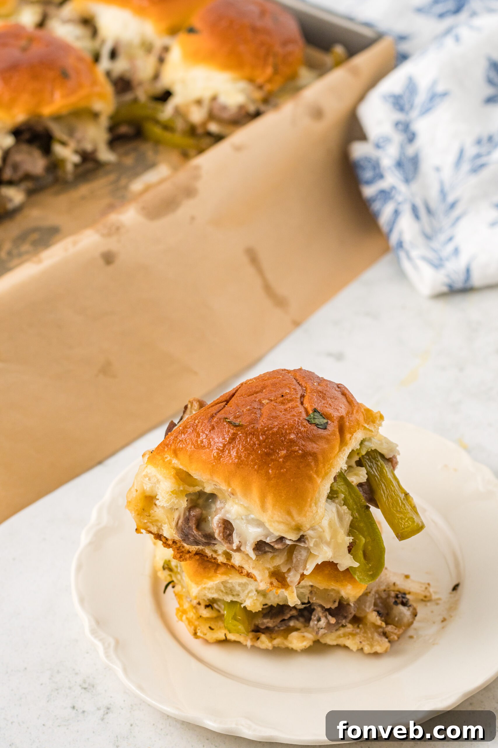 Ultimate Philly Cheesesteak Sliders 4 Two sliders stacked on a white plate.