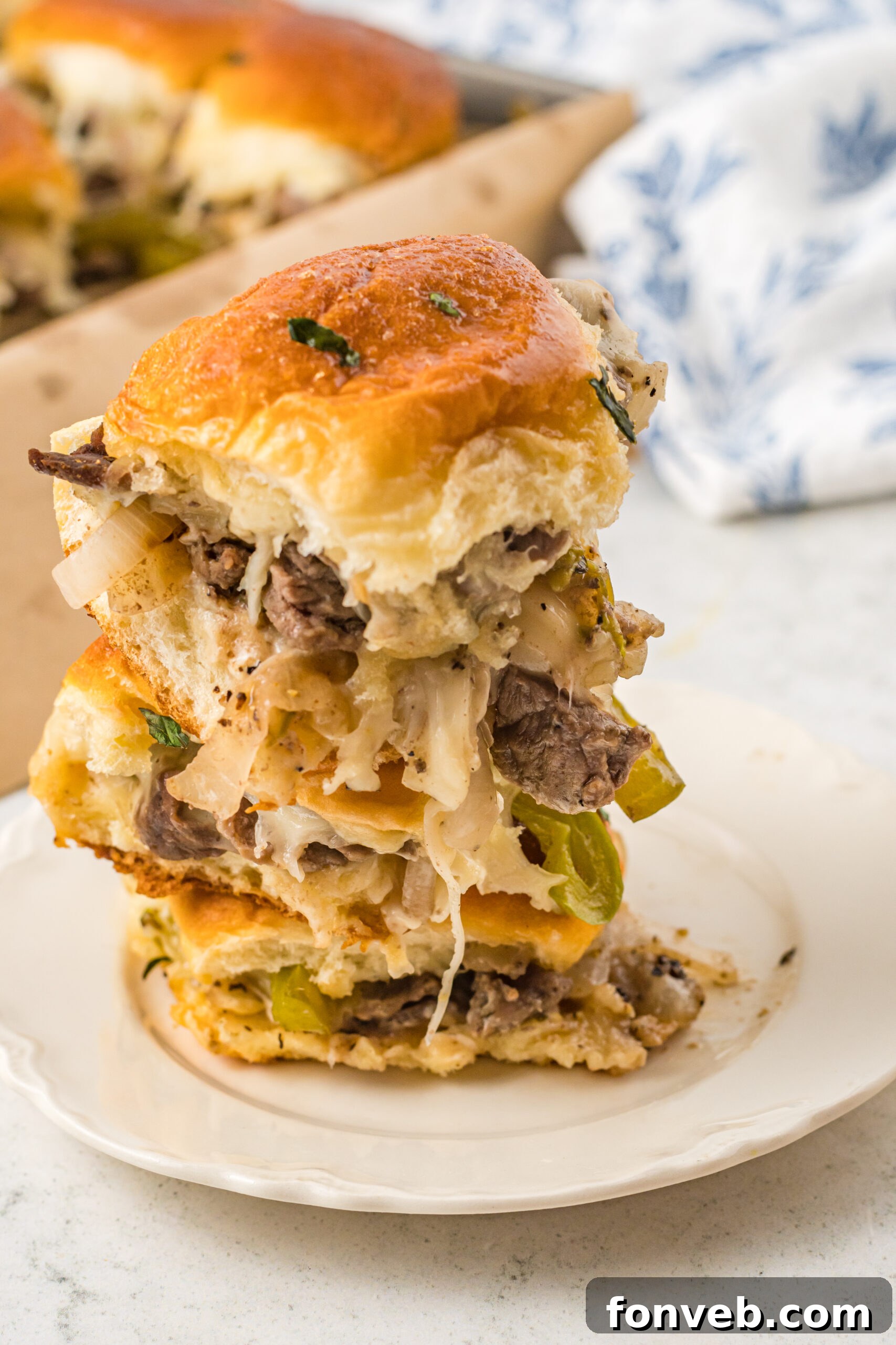 Ultimate Philly Cheesesteak Sliders 5 Three sliders stacked on a white plate.