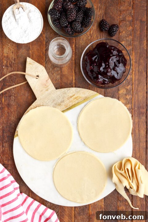 three circle of pie dough on a marble serving tray showing the in process of creating this recipe.