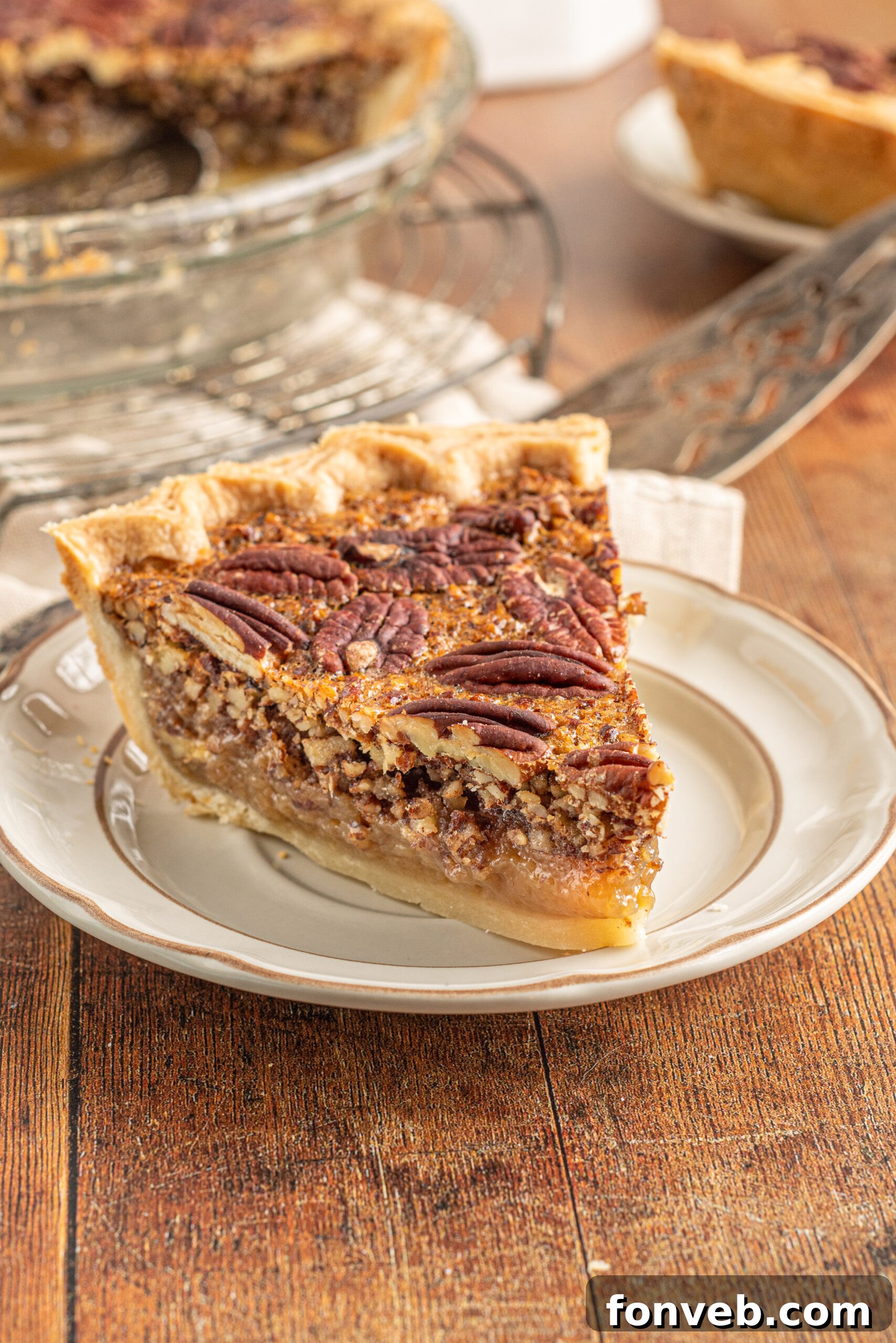 Bourbon Pecan Indulgence 5 A piece of pecan pie on a tan and brown plate.