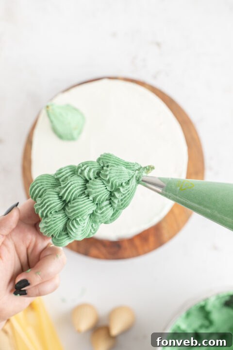 A layer of cake being frosted with green buttercream.