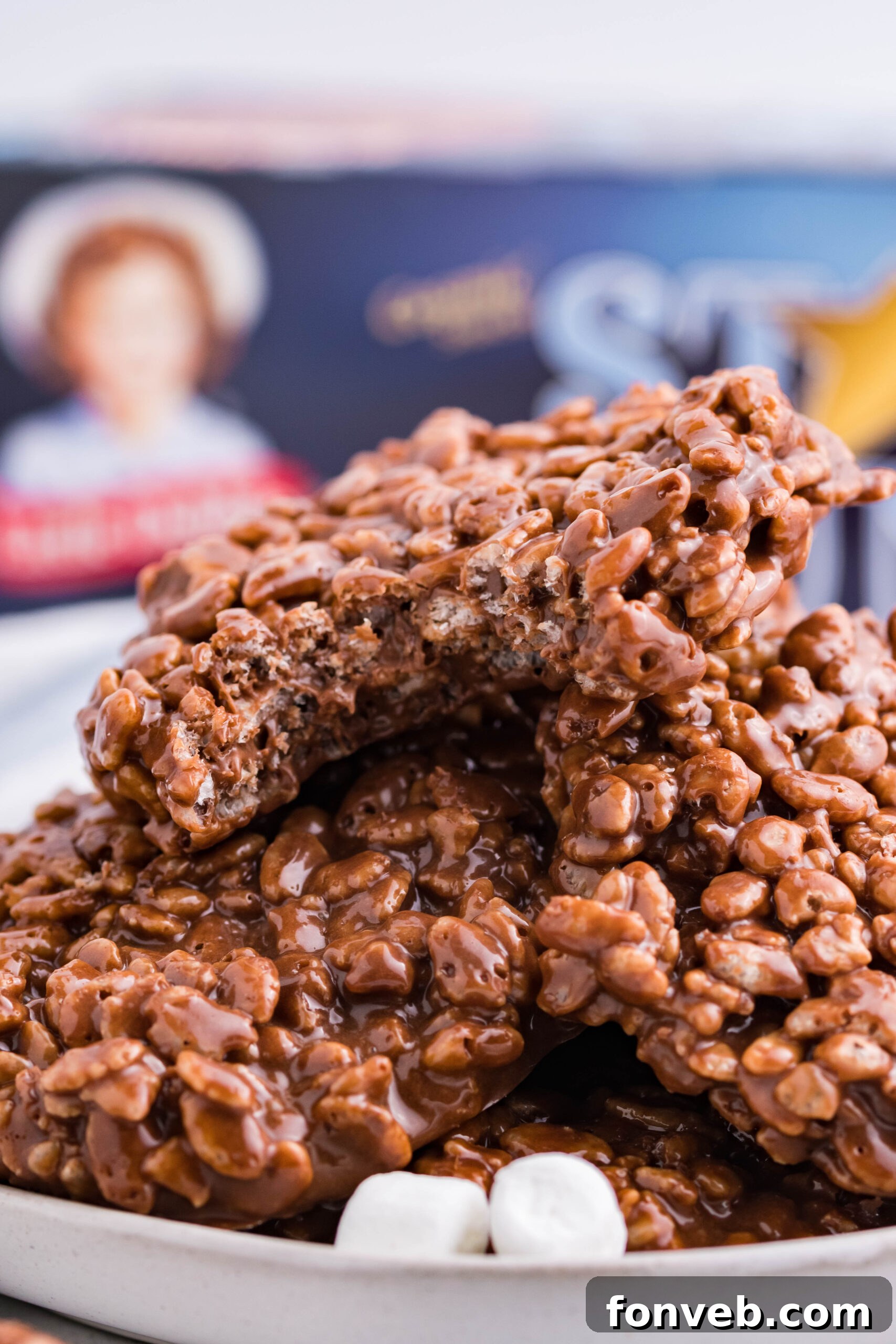A stack of golden-brown homemade Star Crunch cookies, rich with chocolate and caramel, resting on a white plate with soft mini marshmallows scattered around, emphasizing their delightful texture and appeal.