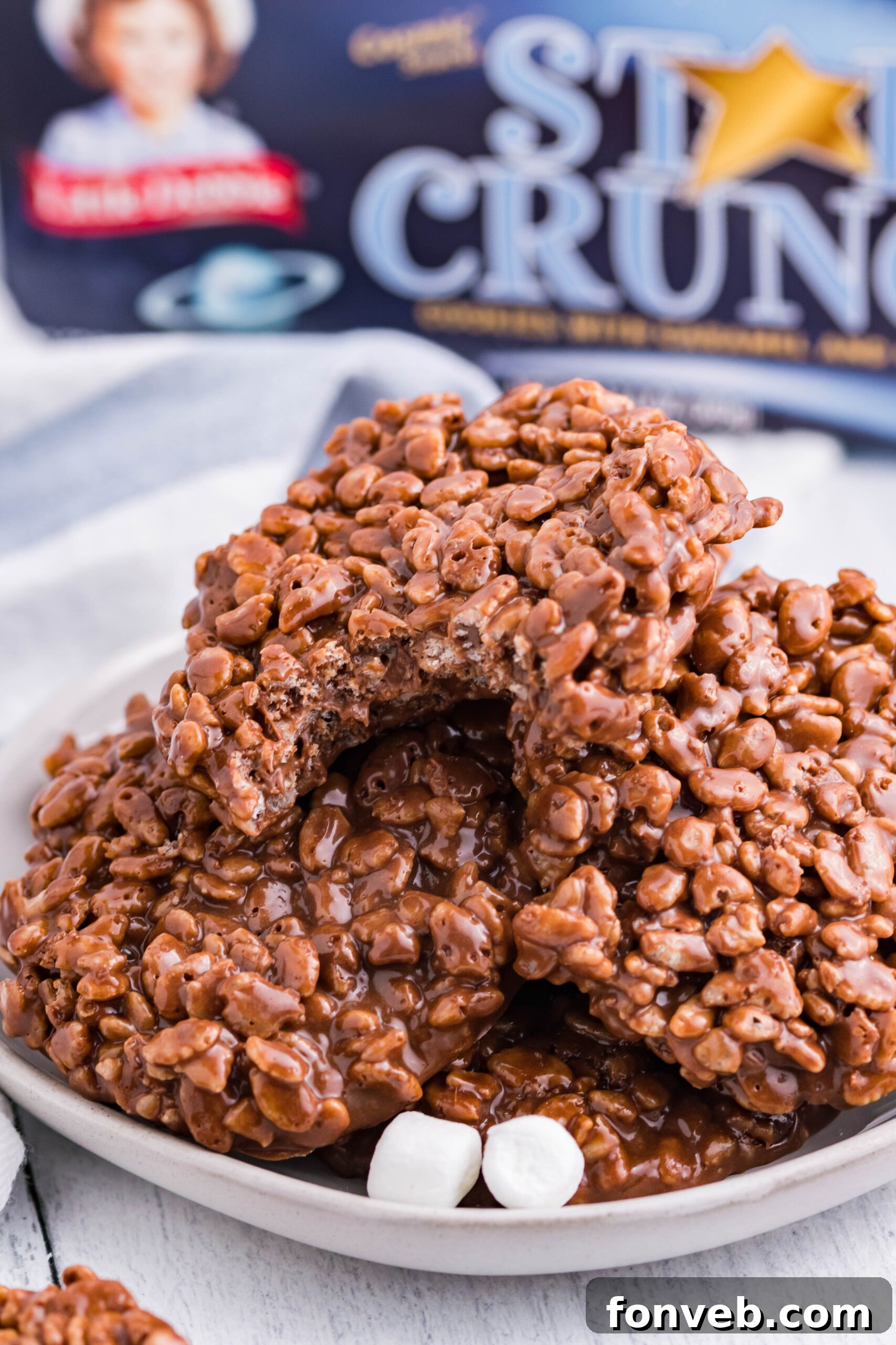An inviting arrangement of freshly prepared Star Crunch copycat cookies, layered on a crisp white plate, with fluffy mini marshmallows providing a soft contrast to the crunchy treats, ready for serving.