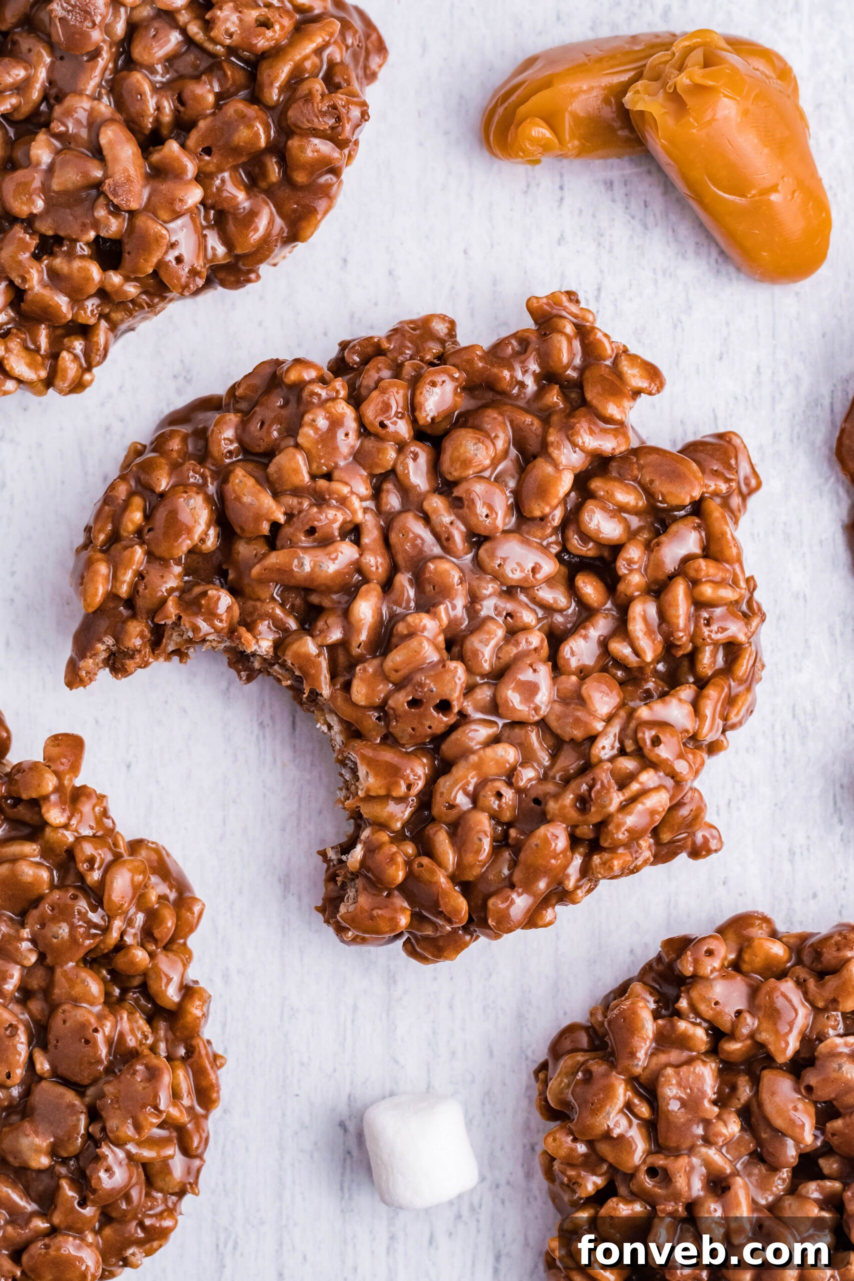An enticing overhead view of a single homemade Star Crunch copycat cookie, expertly crafted with its signature ripples, displaying a missing bite to highlight its layered chocolate, caramel, and crispy rice cereal filling.