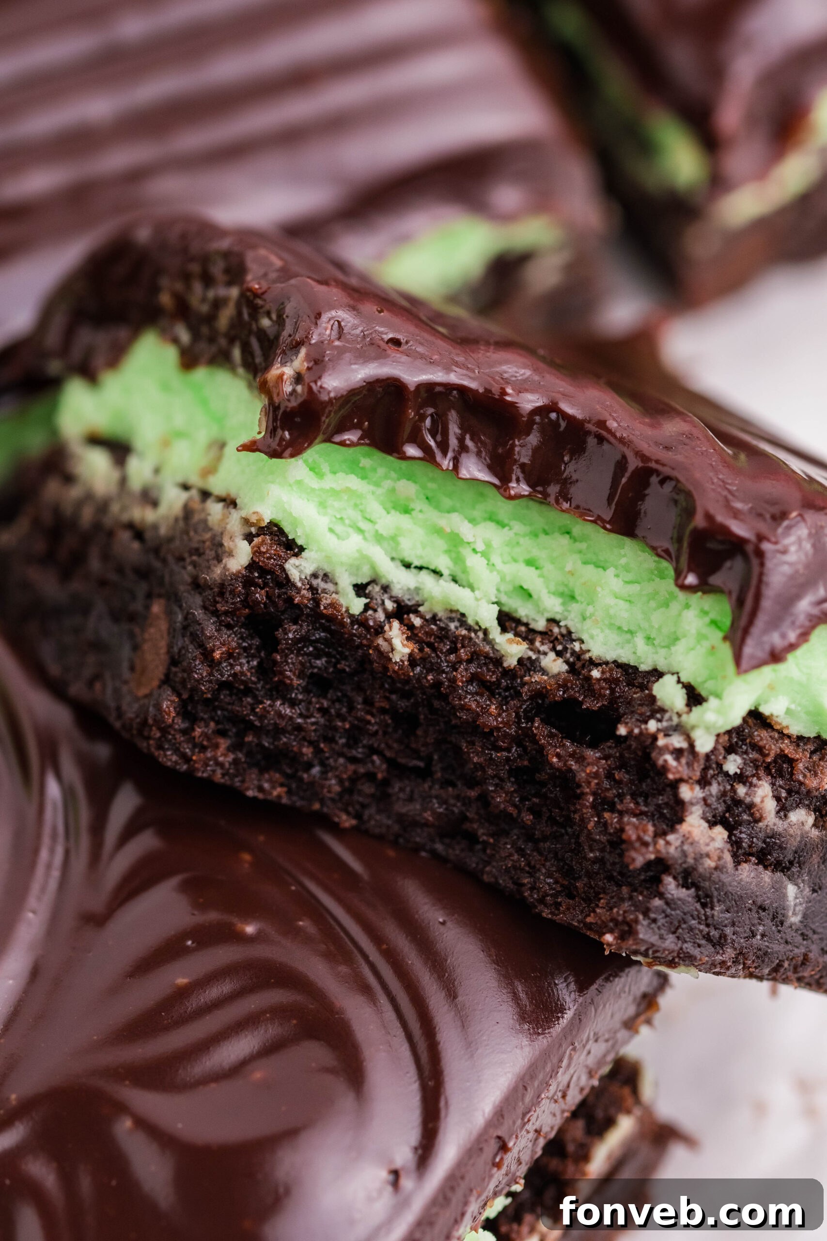 A brownie stacked on top of another with a bite removed.