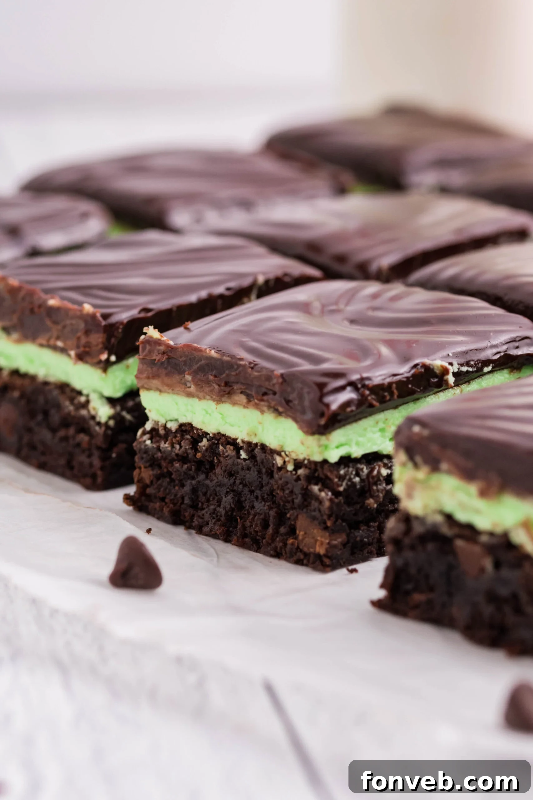 Side view of the brownies showing the brownie, mint frosting, and chocolate layers.
