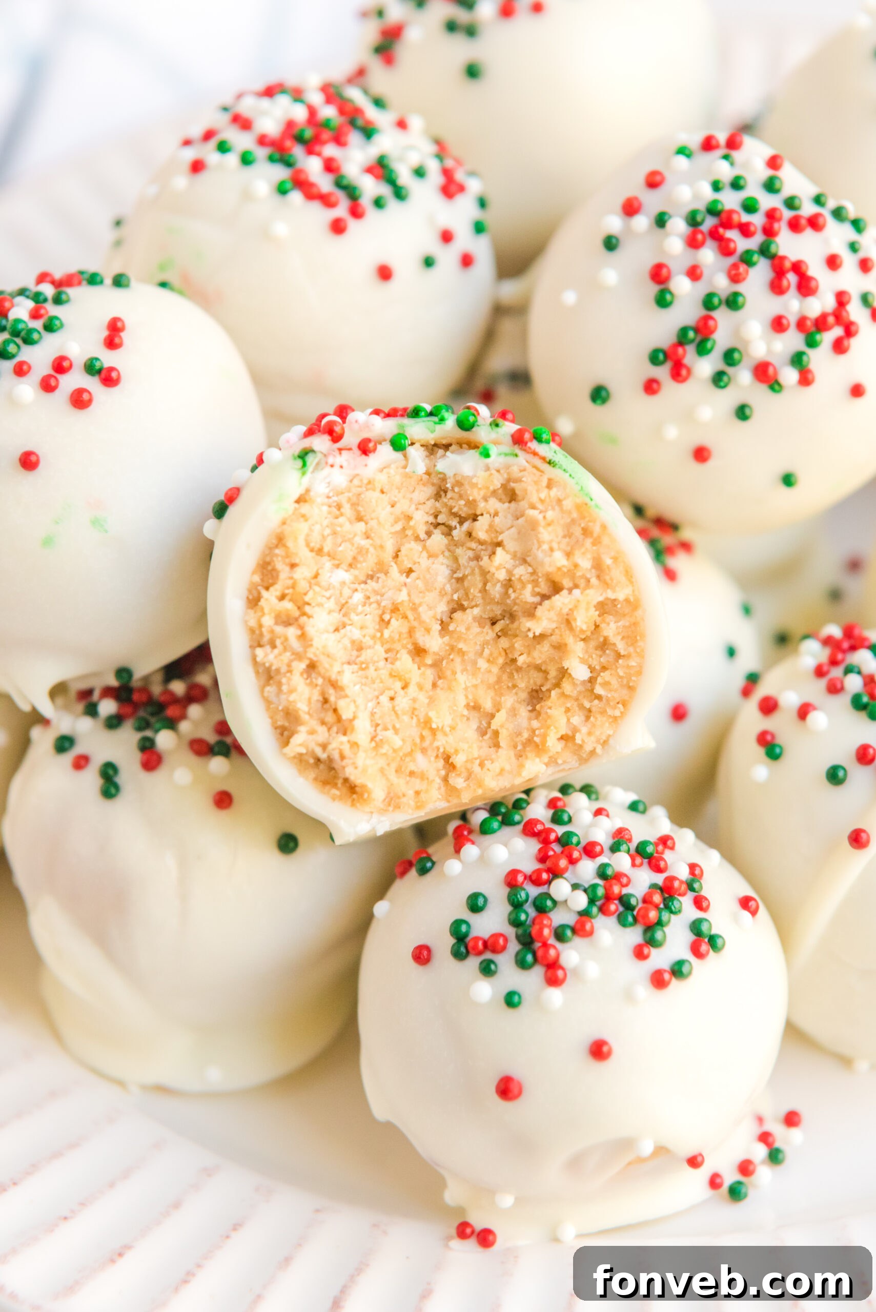 A White Chocolate Peanut Butter Snowball with a bite removed showing the inside. 
