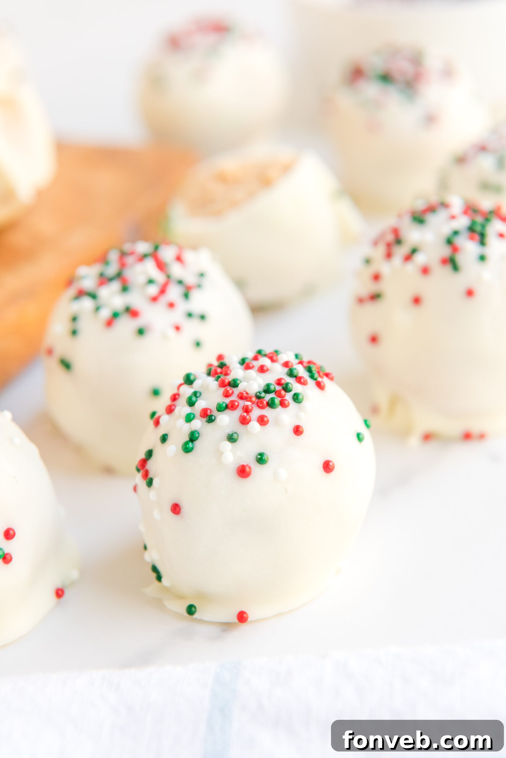Close up of white chocolate peanut butter truffles topped with red, white, and green sprinkles. 