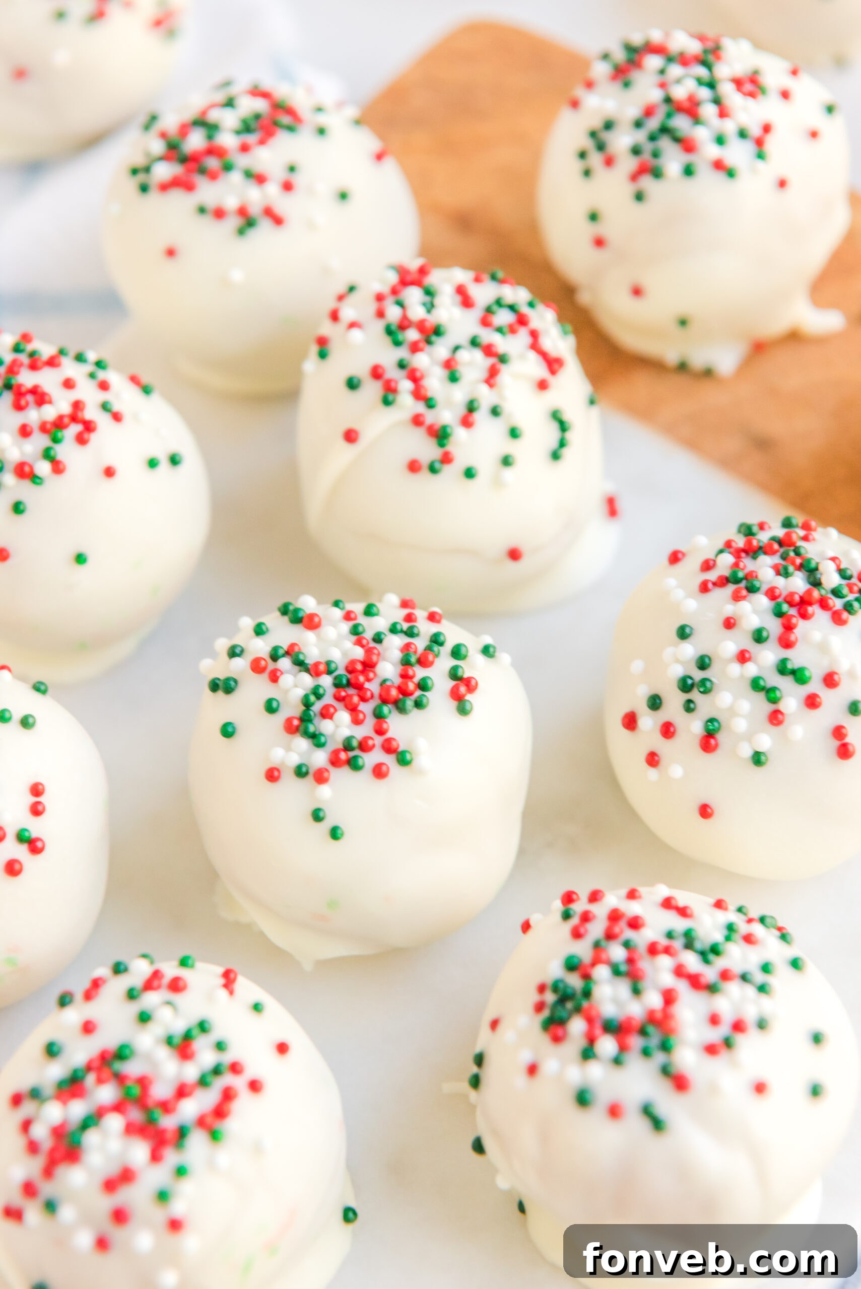 Close up of white chocolate peanut butter truffles topped with red, white, and green sprinkles. 
