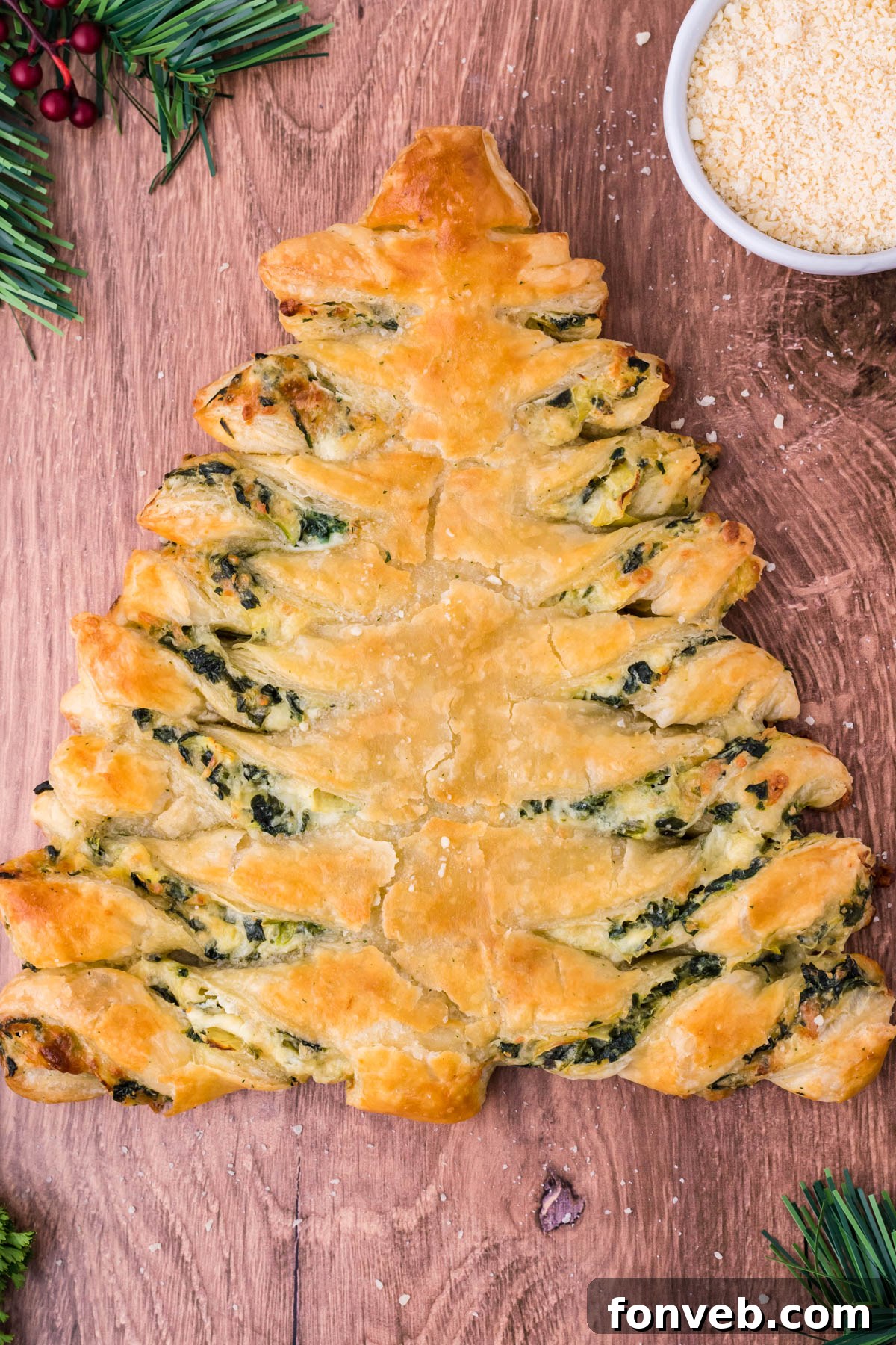 Tear and Share Christmas Spinach Artichoke Bread 2 Overhead view of a beautifully baked Spinach Artichoke Dip Pull Apart Christmas Tree Bread, garnished with fresh herbs, on a rustic dark wood background.