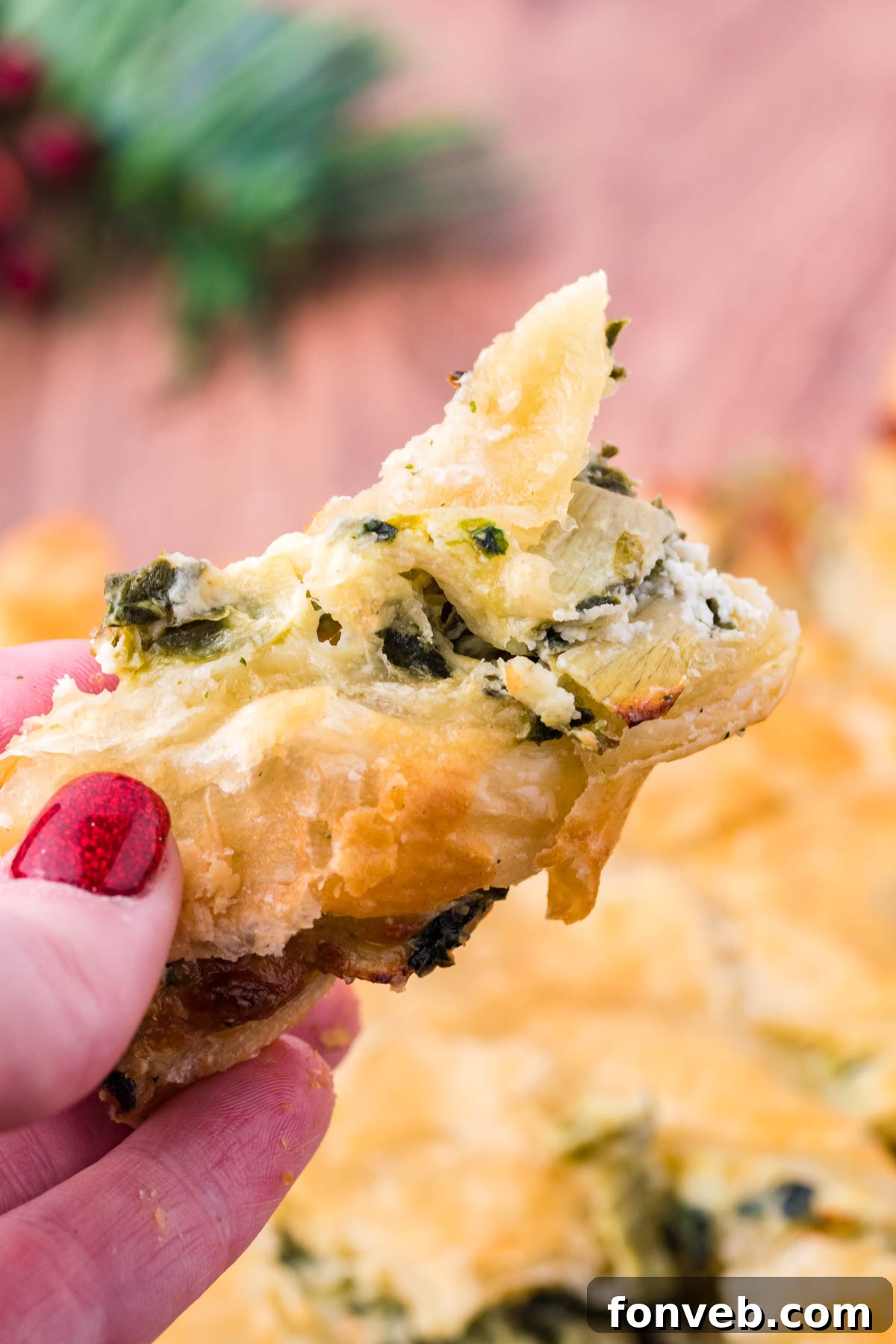 Tear and Share Christmas Spinach Artichoke Bread 8 Close-up of a piece of the Spinach Artichoke Dip Pull Apart Christmas Tree Bread, showcasing its perfectly flaky exterior and the savory filling inside.