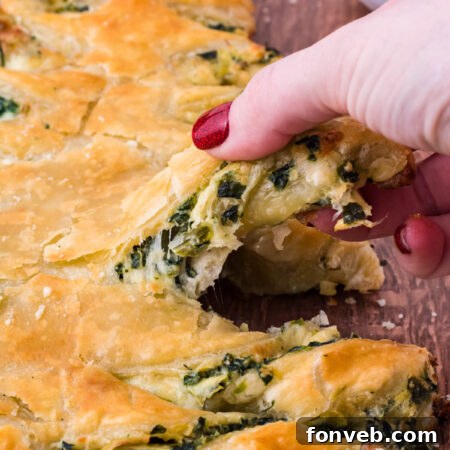 Tear and Share Christmas Spinach Artichoke Bread 10 Overhead view of a beautifully baked Spinach Artichoke Dip Pull Apart Christmas Tree Bread, garnished with fresh herbs, on a rustic dark wood background.