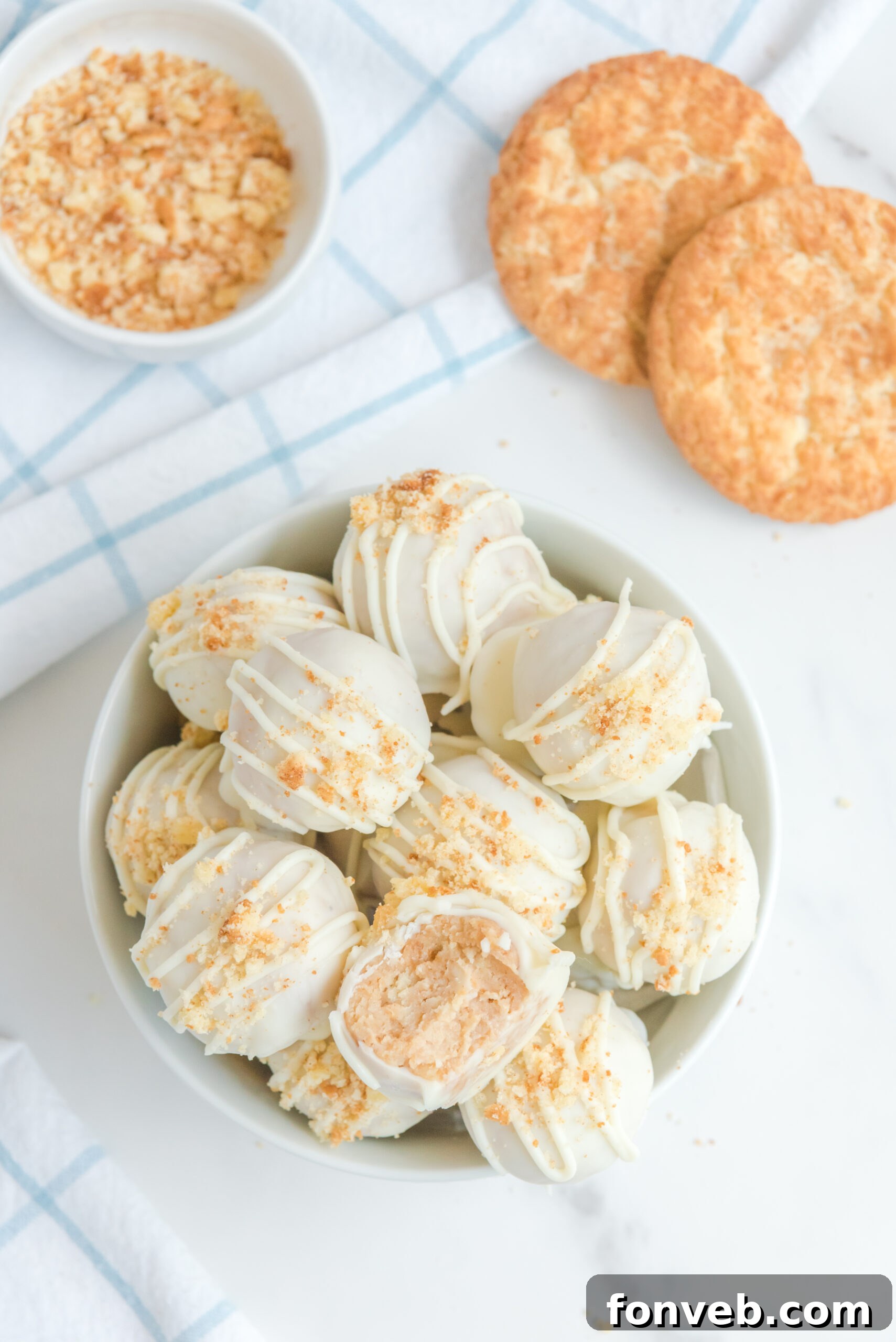 An overhead shot of snickerdoodle truffles in a white bowl topped with crushed snickerdoodles.