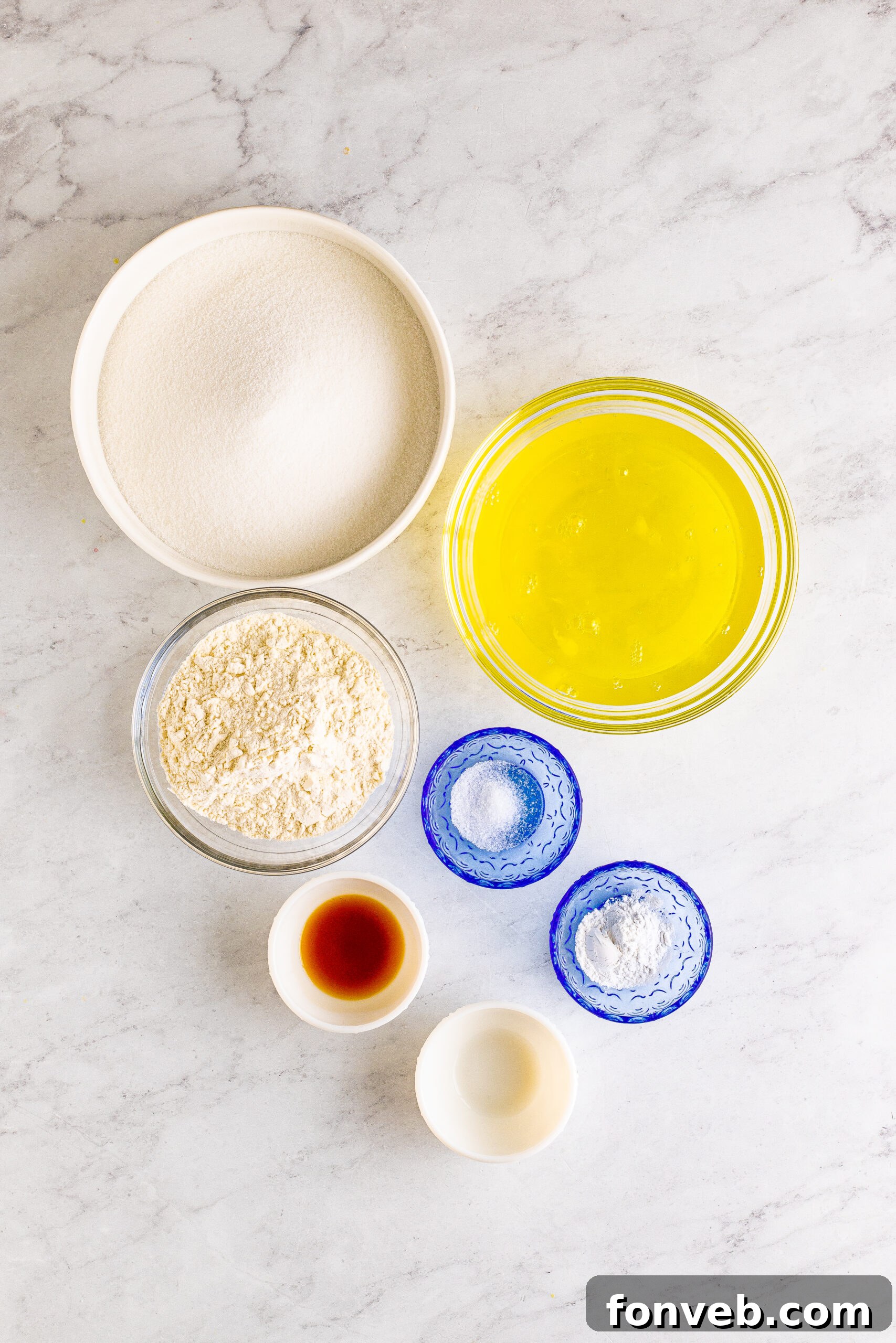 A selection of the key ingredients laid out: flour, sugar, salt, cream of tartar, vanilla extract, and egg whites, ready for baking this delicate cake.