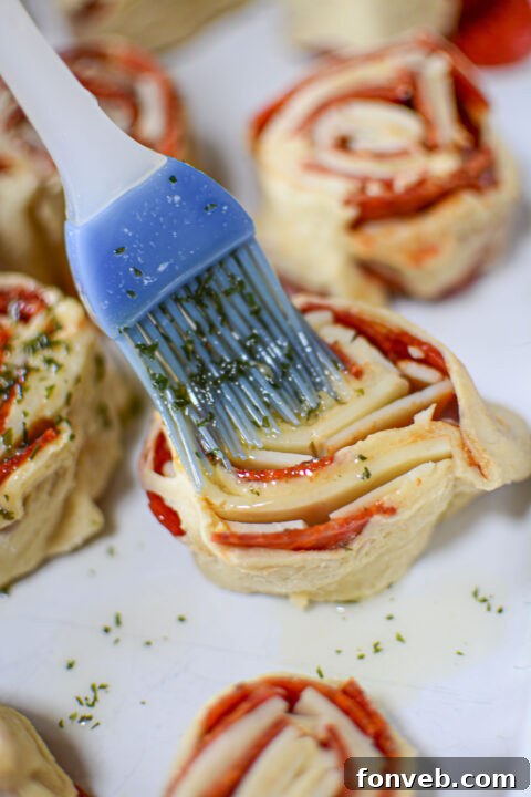 Swirled Pizza Bites 11 Pinwheels neatly sliced and arranged in a baking dish.