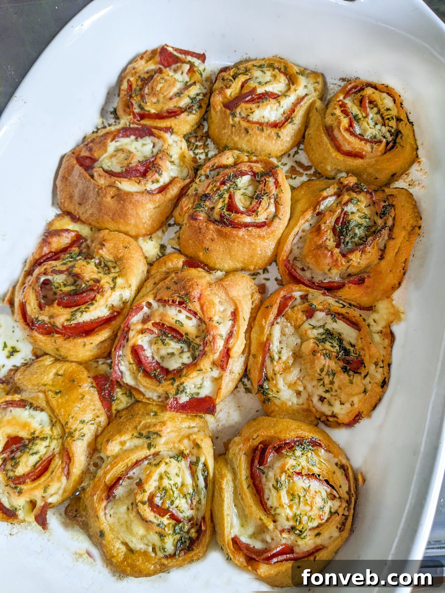 Swirled Pizza Bites 13 Sliced pizza pinwheels arranged on a white plate, showing the perfect spirals.