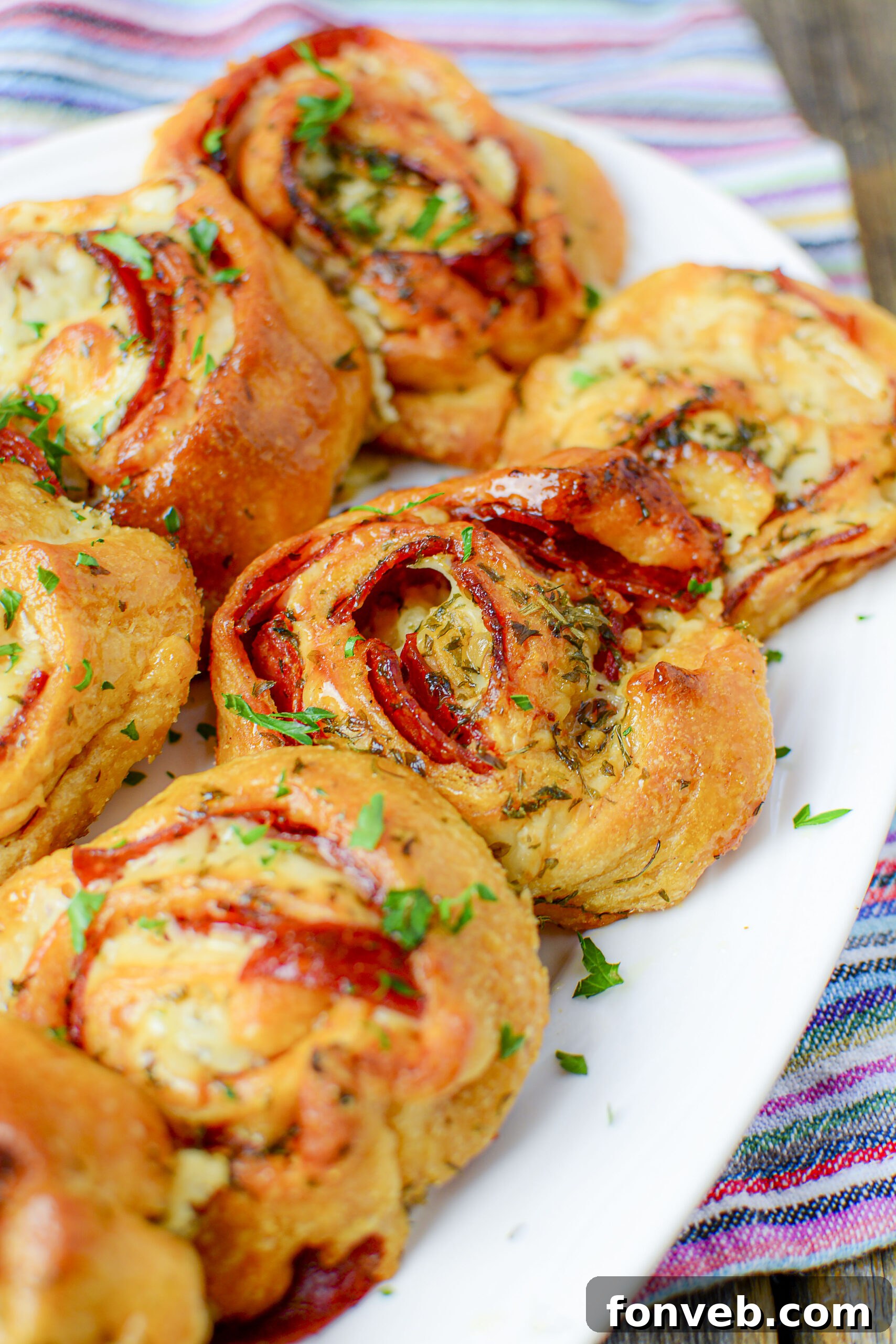 Swirled Pizza Bites 3 Close-up overhead shot of freshly baked pizza pinwheels, showcasing their golden crust and cheesy filling.