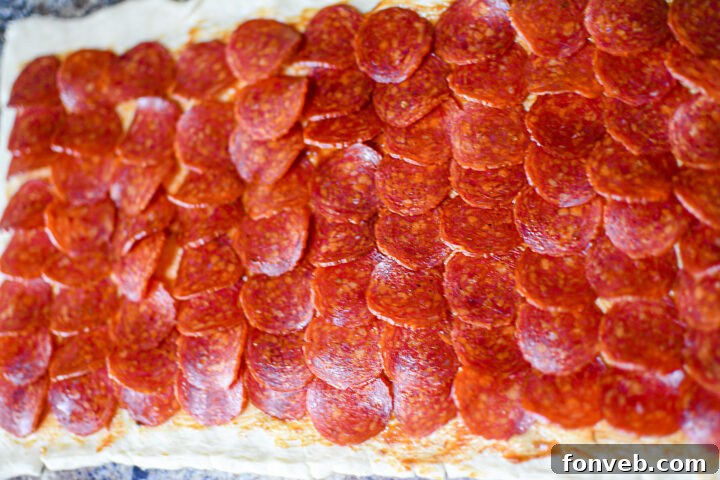 Swirled Pizza Bites 7 Various stages of pizza pinwheel preparation and baking, from rolled dough to finished pinwheels.