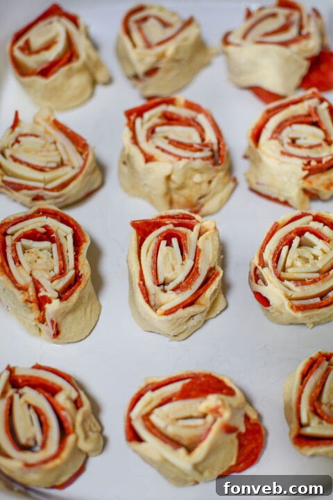 Swirled Pizza Bites 9 Dough layered with pepperoni and cheese, showcasing the filling before rolling.
