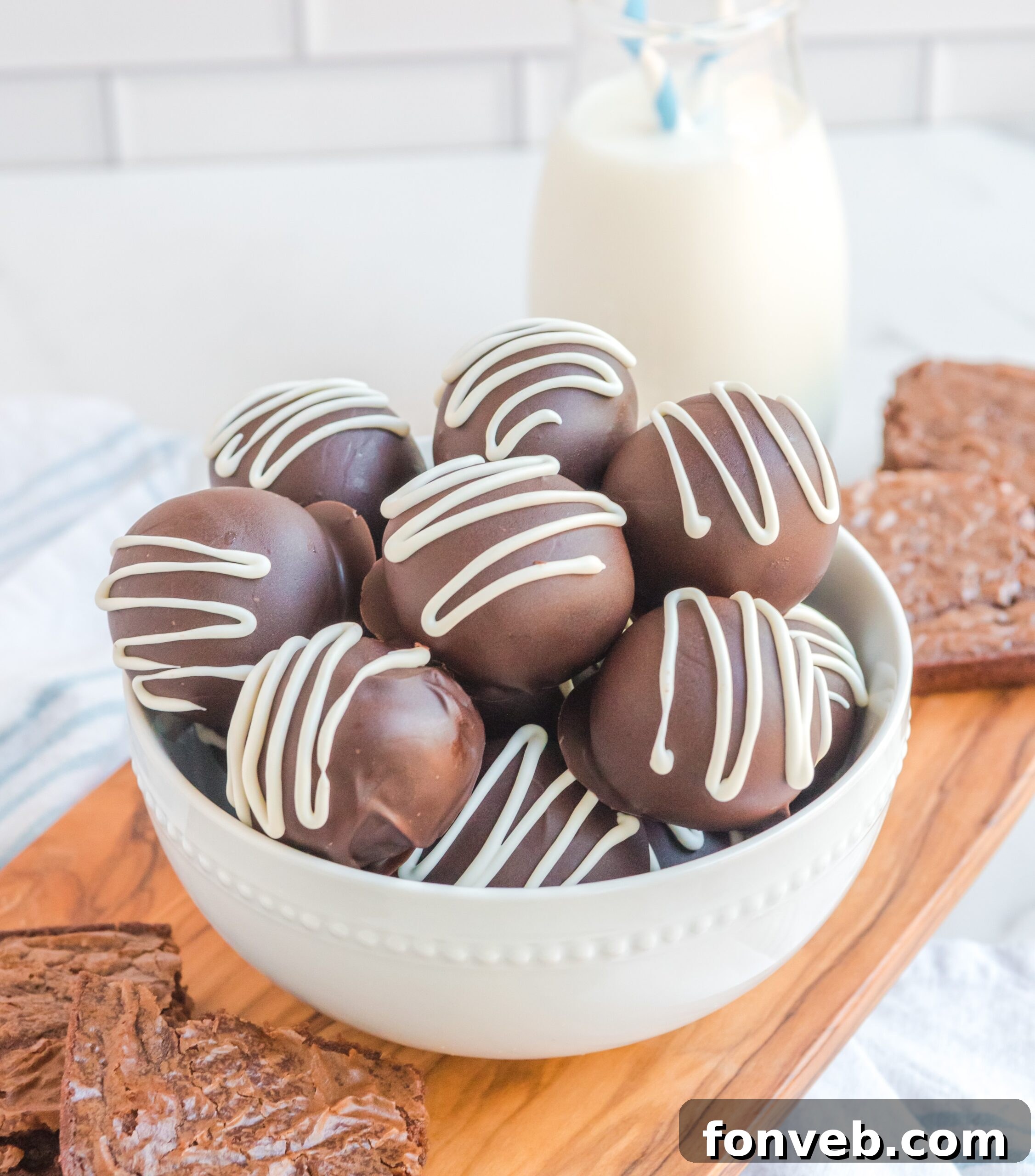 Decadent Brownie Bites 17 Brownie Bite Truffles in a white bowl with a glass of milk behind them