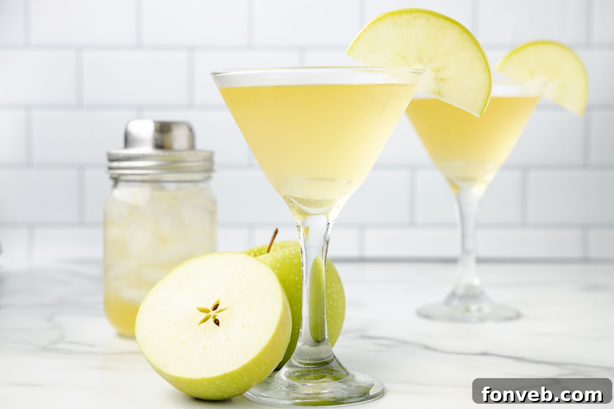 Side view of a perfectly mixed Appletini in a martini glass, garnished with a single, elegant apple slice.