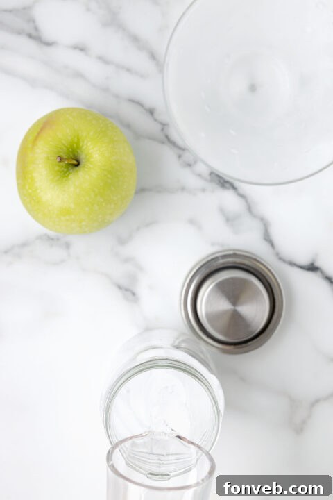 Step-by-step image of adding apple vodka to a shaker.