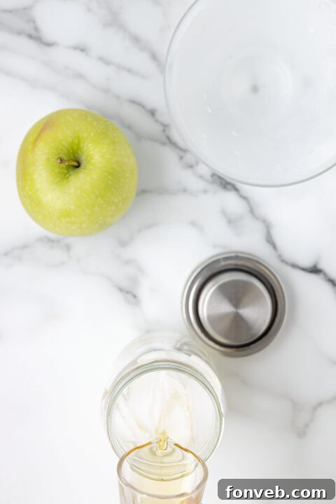 Adding apple juice to the cocktail shaker.
