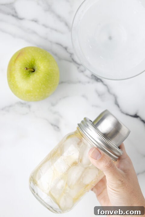 Pouring the mixed Appletini into a chilled glass.