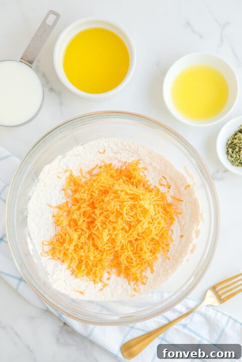 Biscuit dough shaped and spaced on a parchment-lined baking sheet