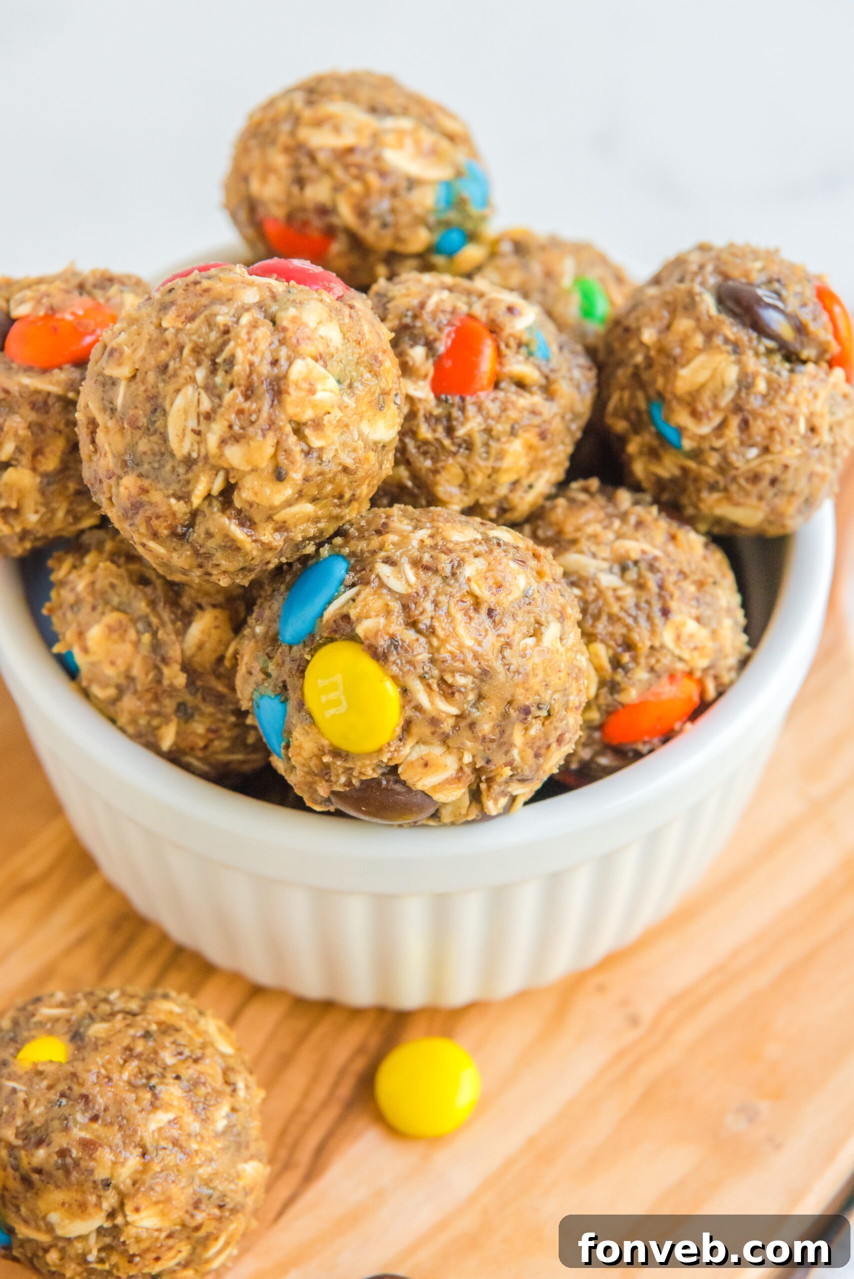 Close up view of No Bake M&M Energy balls in a white bowl.