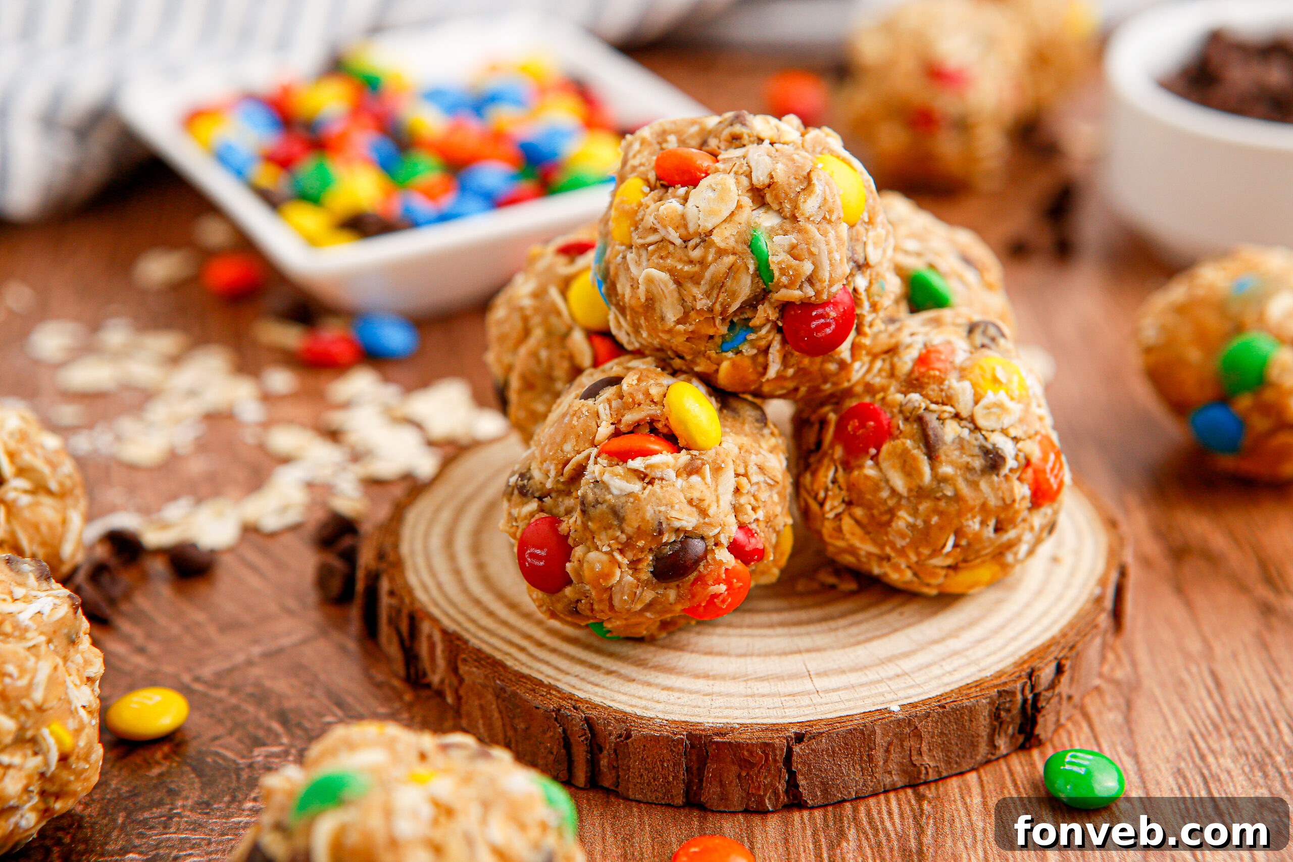 Close up view of No Bake M&M Energy balls on a small wooden serving platter
