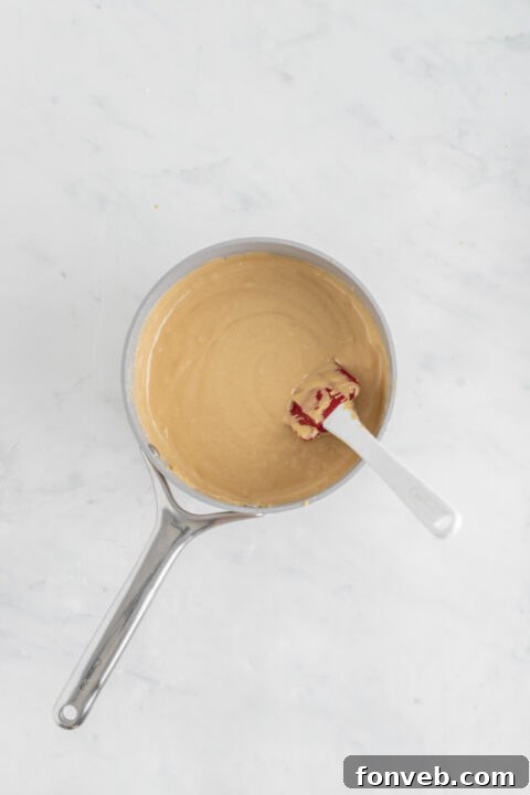 Marshmallow fluff being stirred into the smooth fudge base.