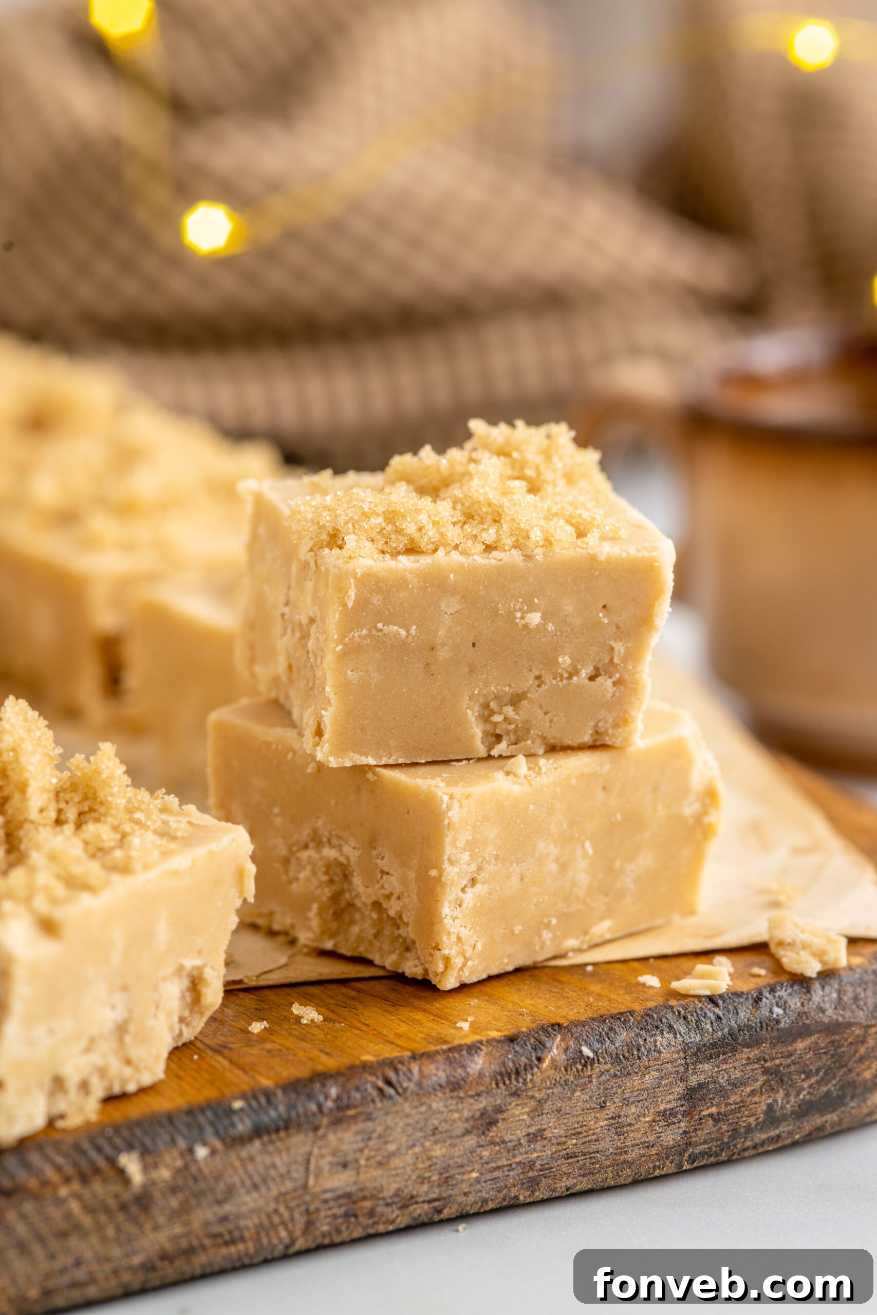 Two pieces of Penuche Fudge displayed elegantly on a wooden board.