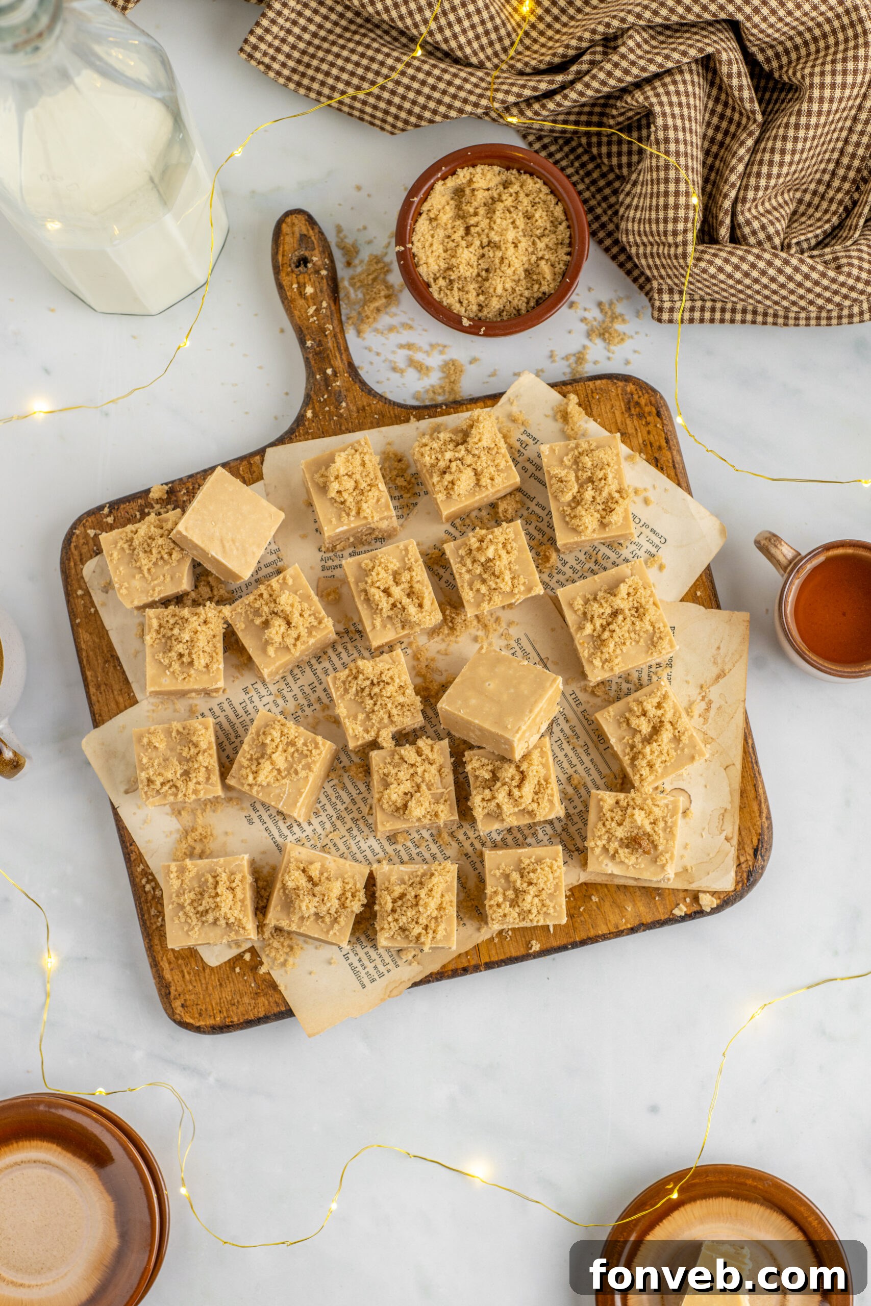 Overhead view of Penuche Fudge squares neatly arranged on a rustic wooden board.