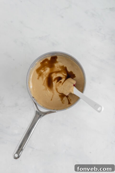 White chocolate chips being added to the hot fudge mixture.