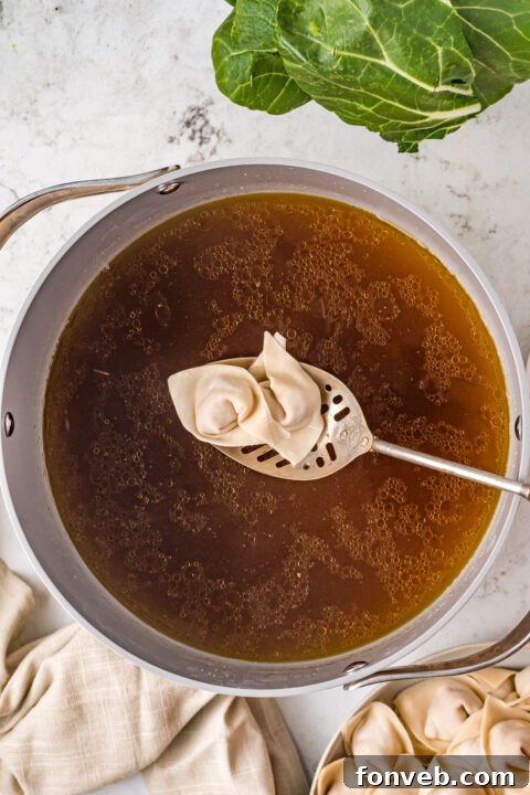 Comforting Wonton Soup 10 Fresh bok choy being added to soup