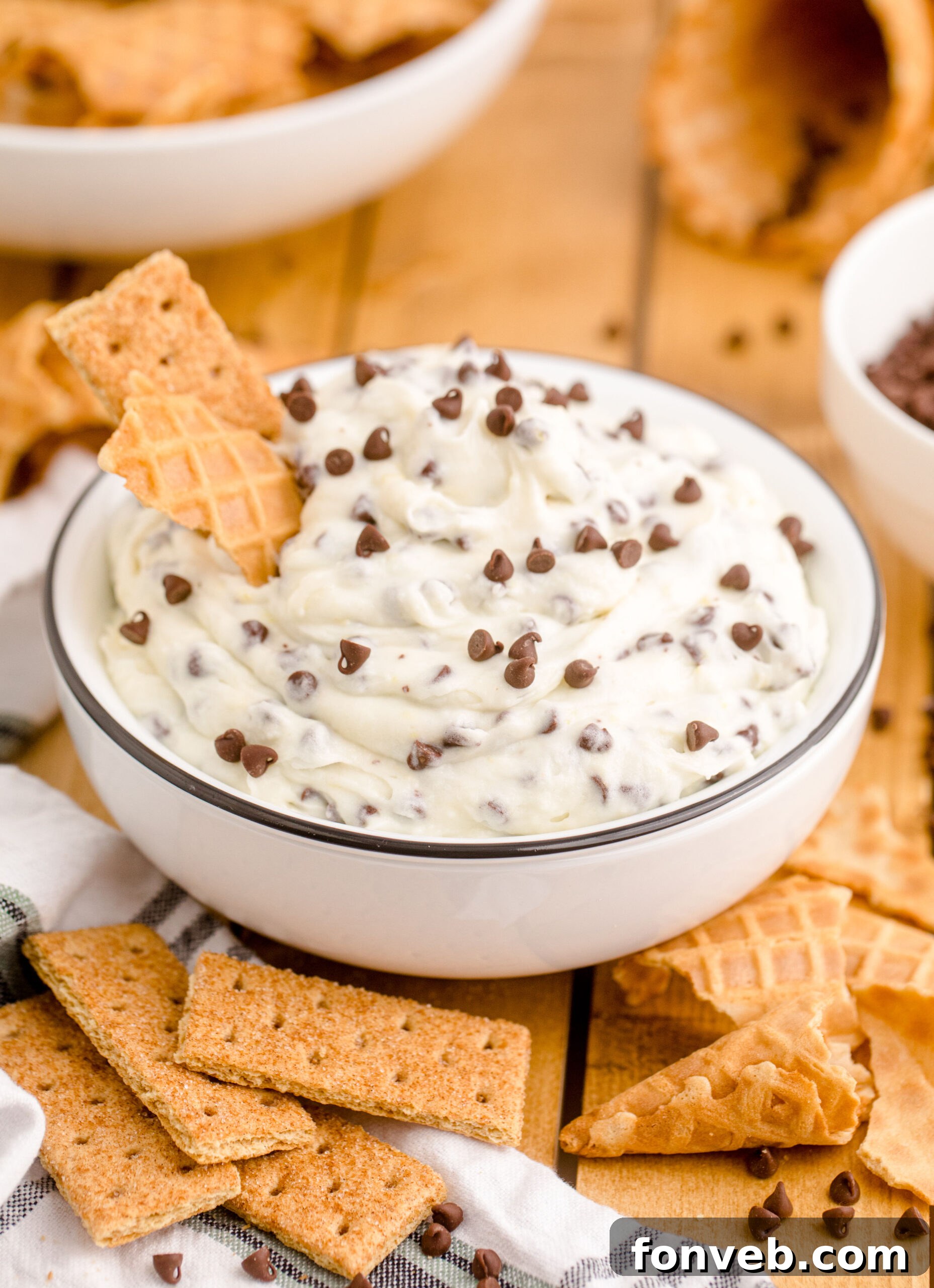 A delectable Cannoli Dip served in a chic black and white dish, garnished with a crisp waffle cone piece, ready for dipping.
