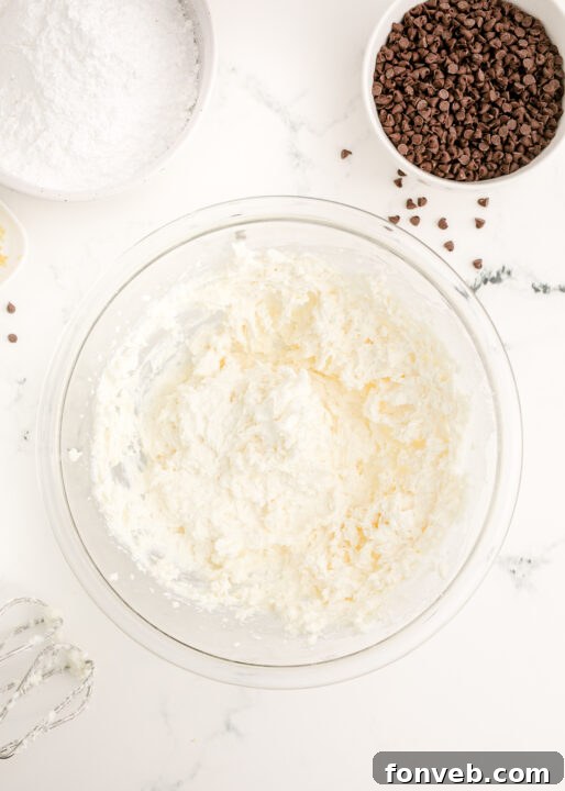 A close-up of cream cheese in a bowl, showing its soft, smooth texture.