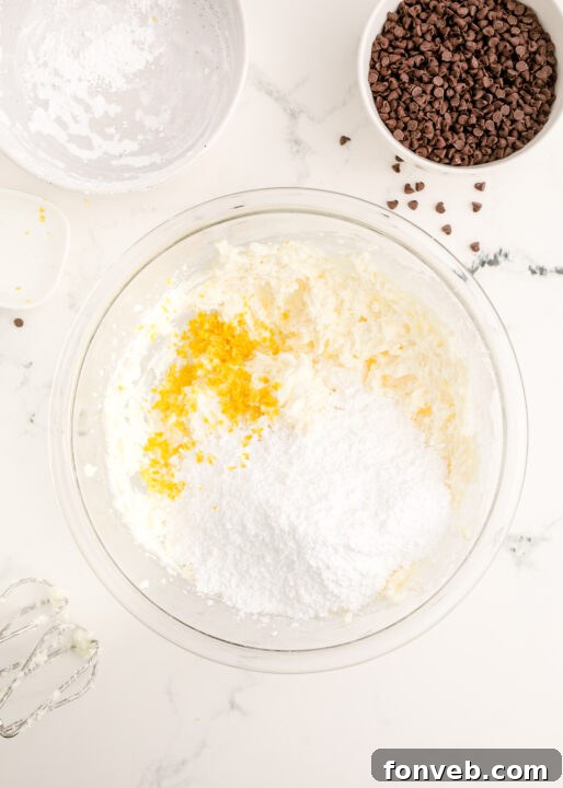 Orange zest being grated into the dip mixture, adding a citrus aroma.