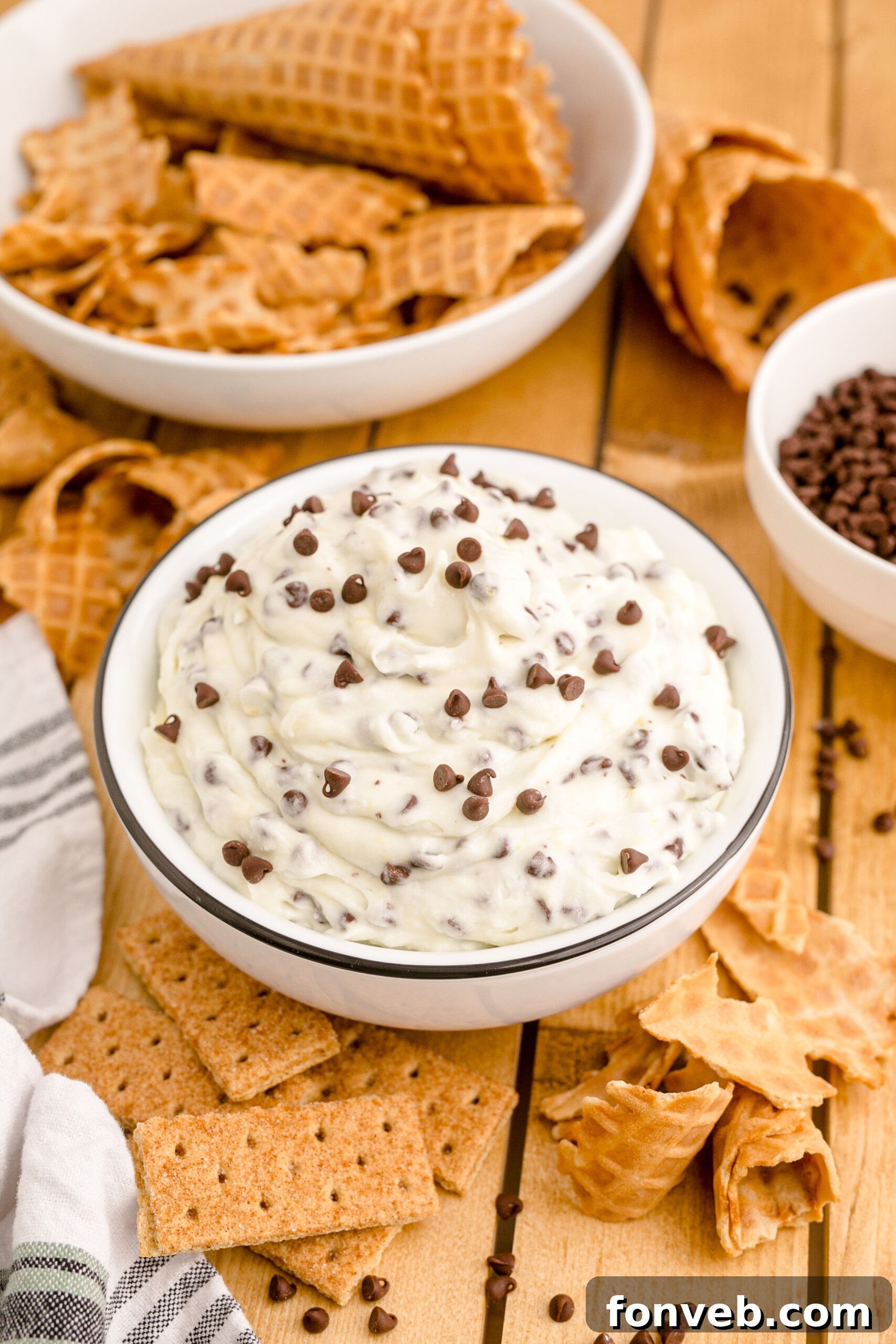A beautifully composed side view of the Cannoli Dip in a black and white dish, resting on a rustic wooden table, inviting a taste.