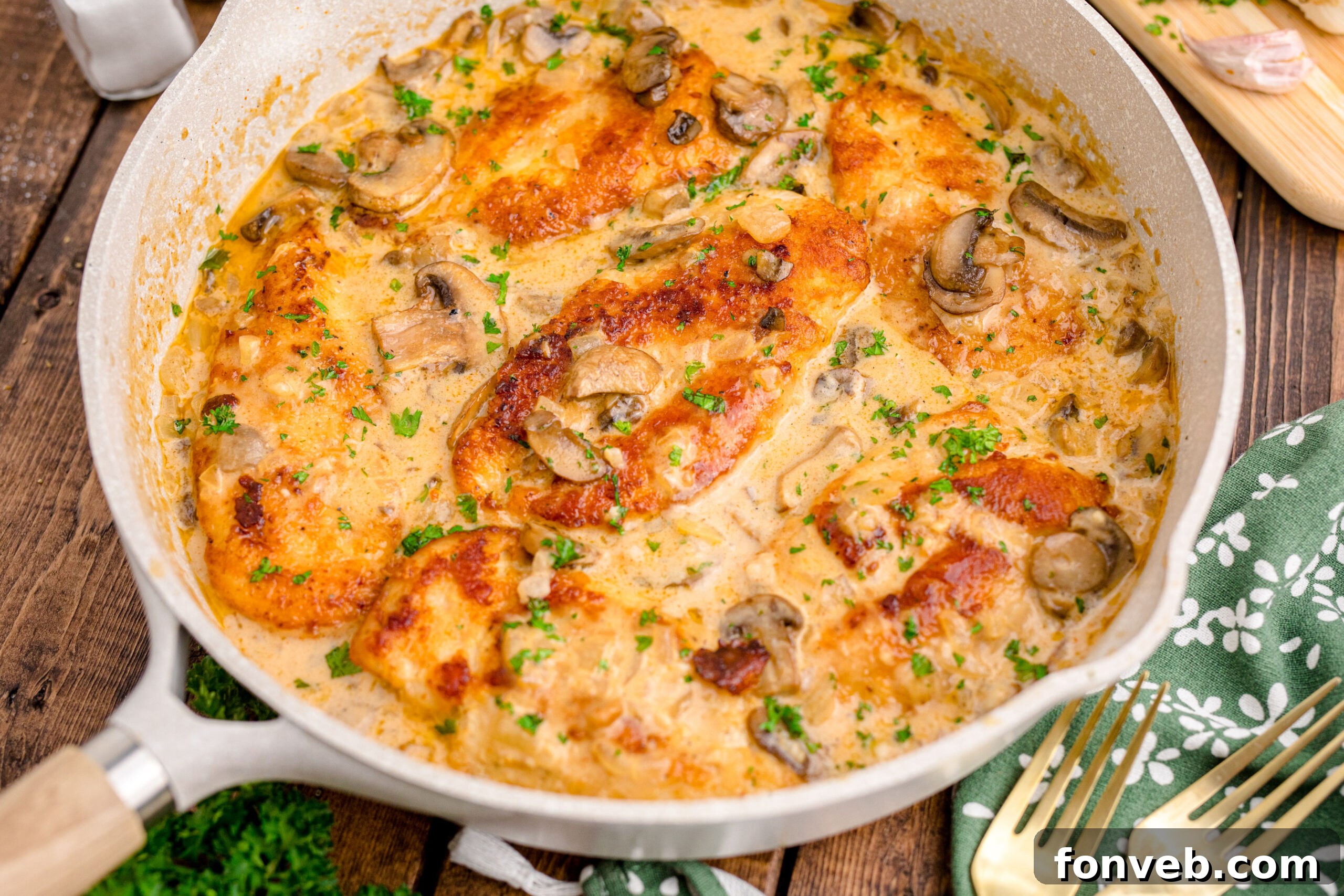Chicken Marsala in a white skillet on a dark wood table 