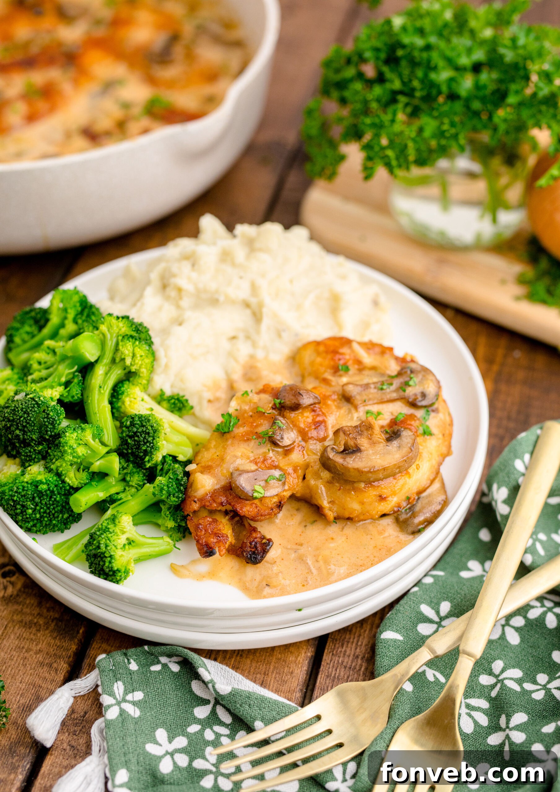 Chicken Marsala on a white plate with a side of broccoli and mashed potatoes 