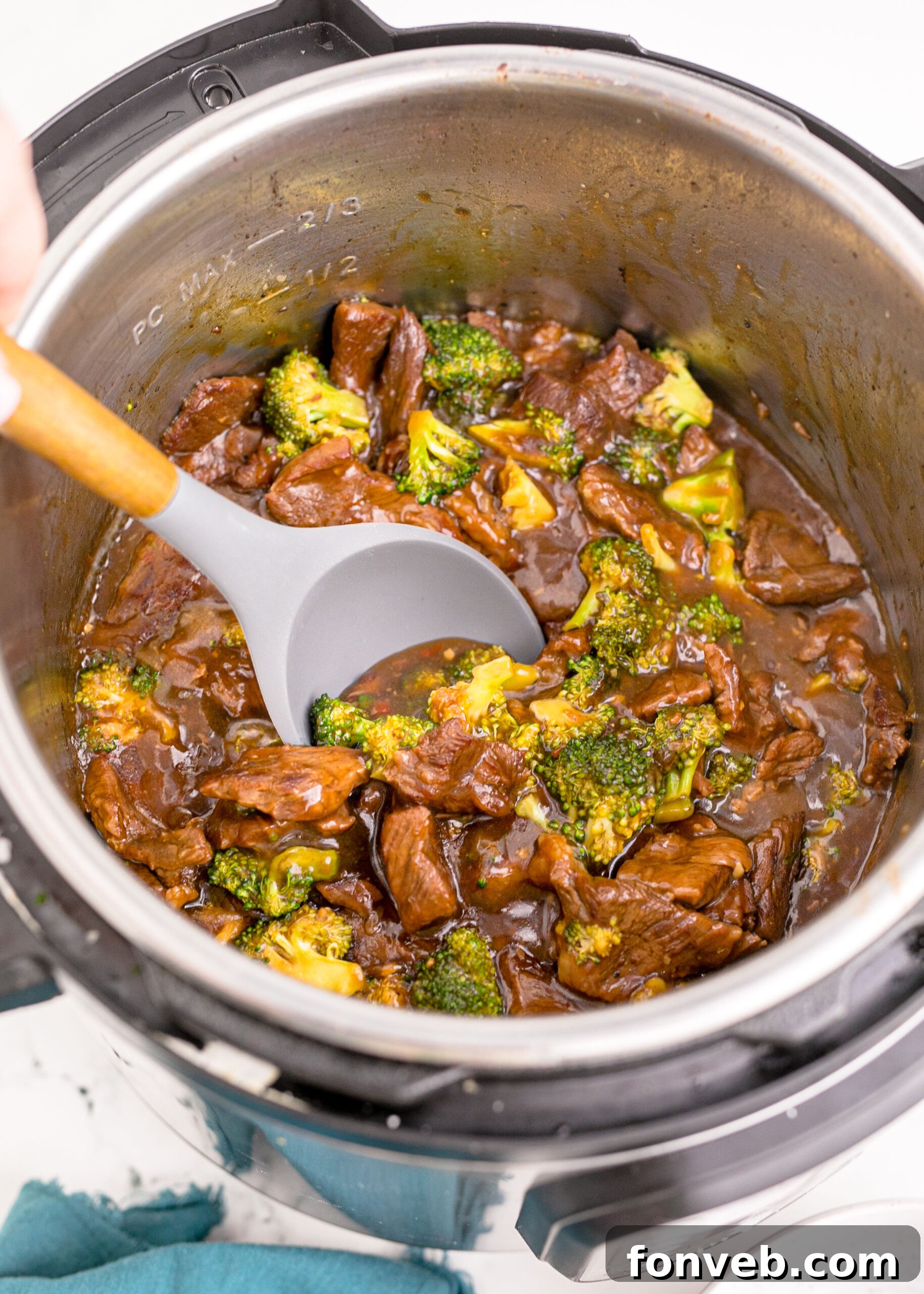 Instantpot Beef & Broccoli in the instantpot showing how delicious it looks with a spoon lifting some