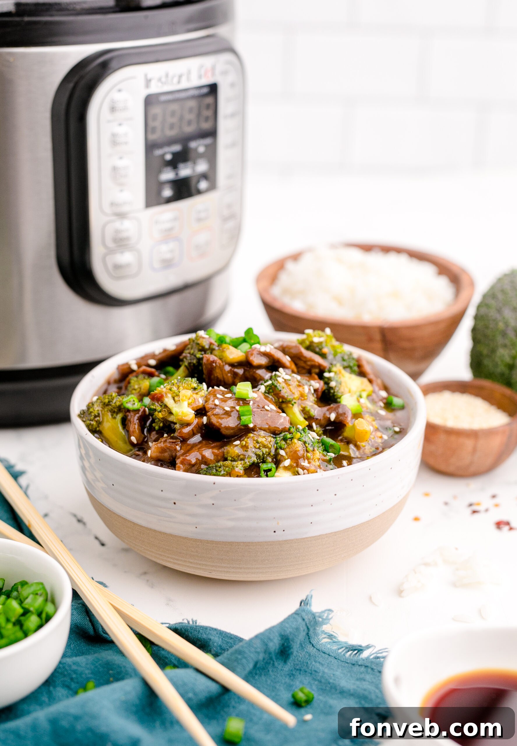 Side view of Instant Pot Beef and Broccoli in a white and tan bowl.