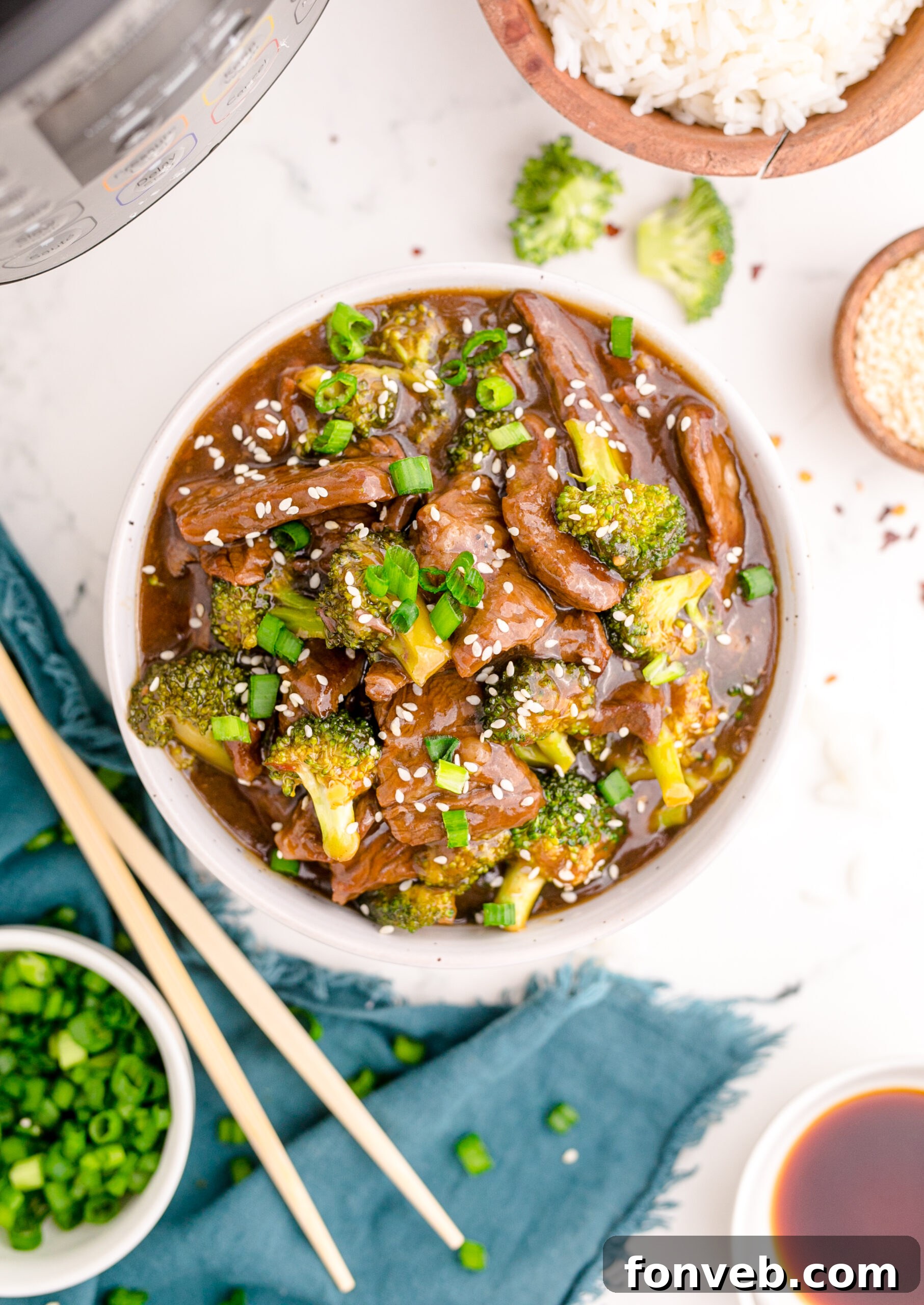 Overhead view of Instant Pot Beef and Broccoli in a white and tan bowl.