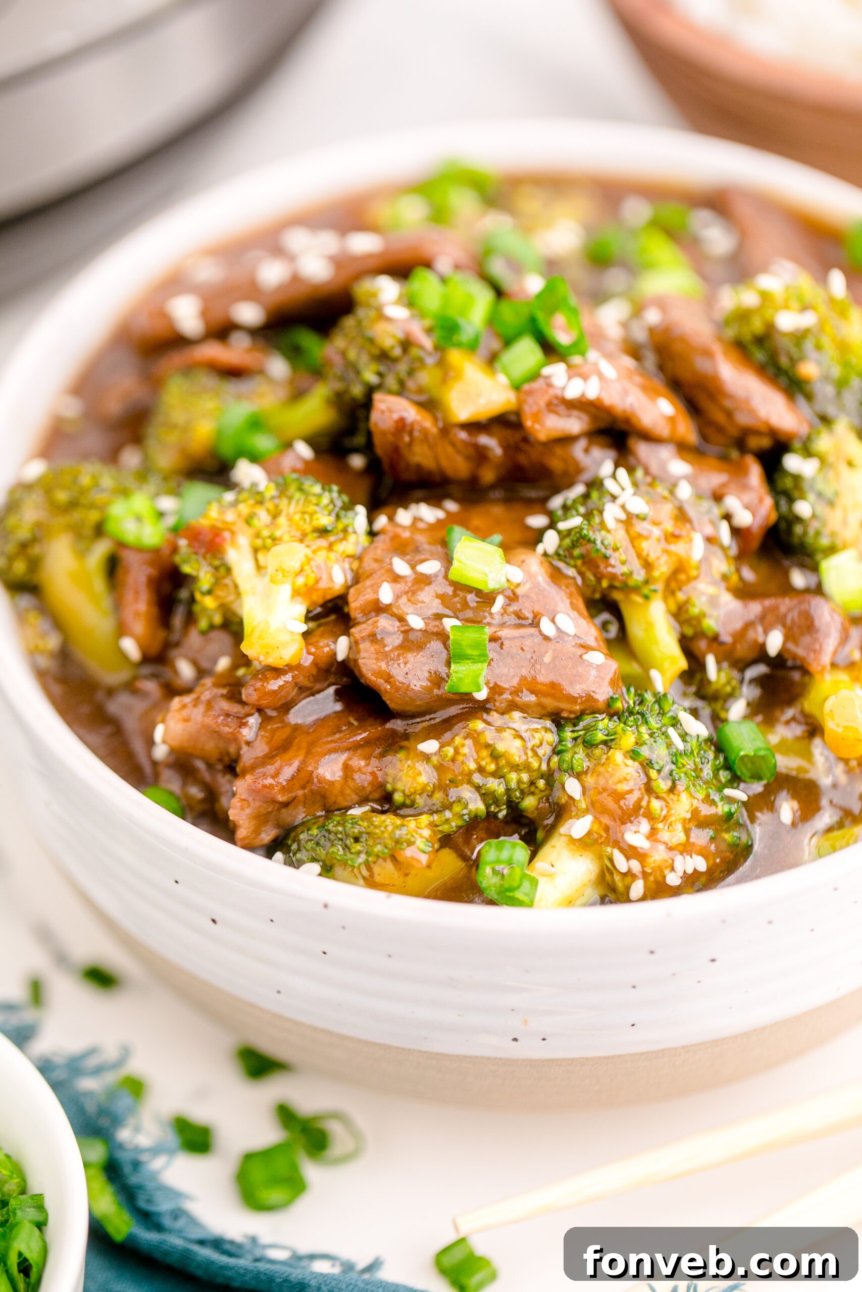 Up close view of Instant Pot Beef and Broccoli in a white and tan bowl.