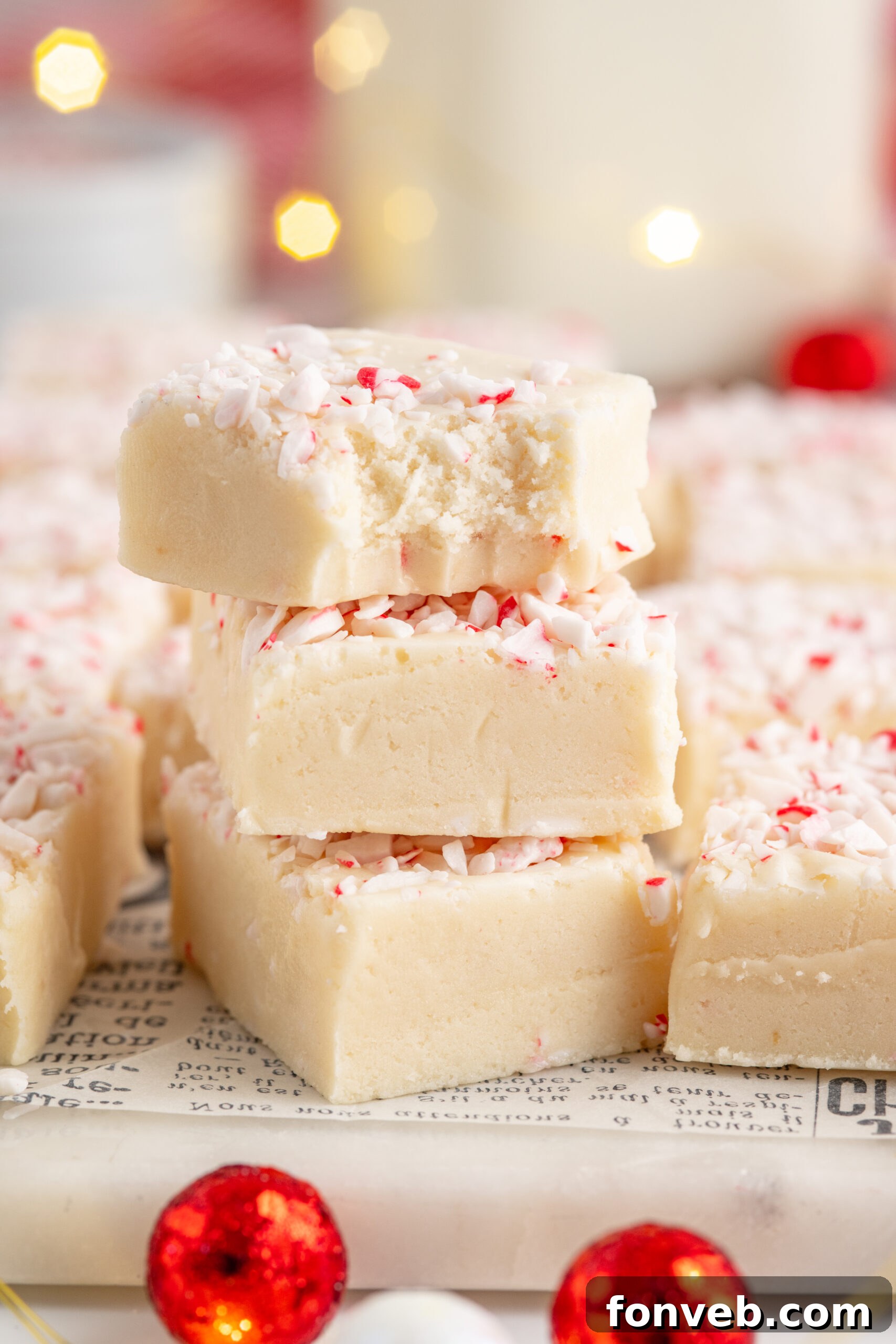 Three pieces of peppermint fudge stacked on top of each other with a bite removed from the top piece.