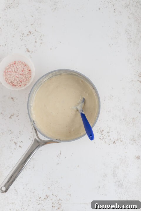 Stirring in peppermint extract to the melted fudge.