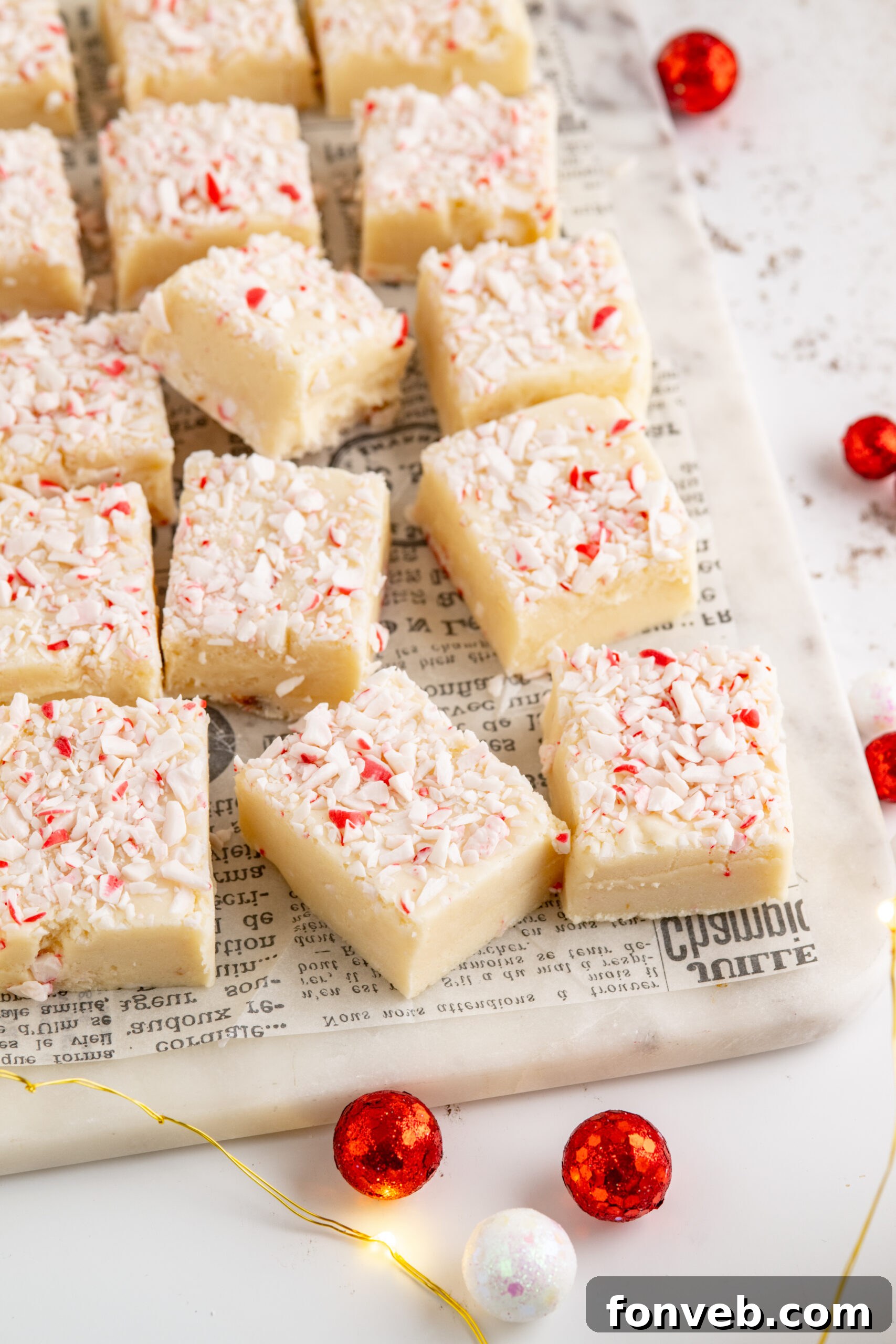 Peppermint fudge cut up into small squares topped with crushed peppermint.